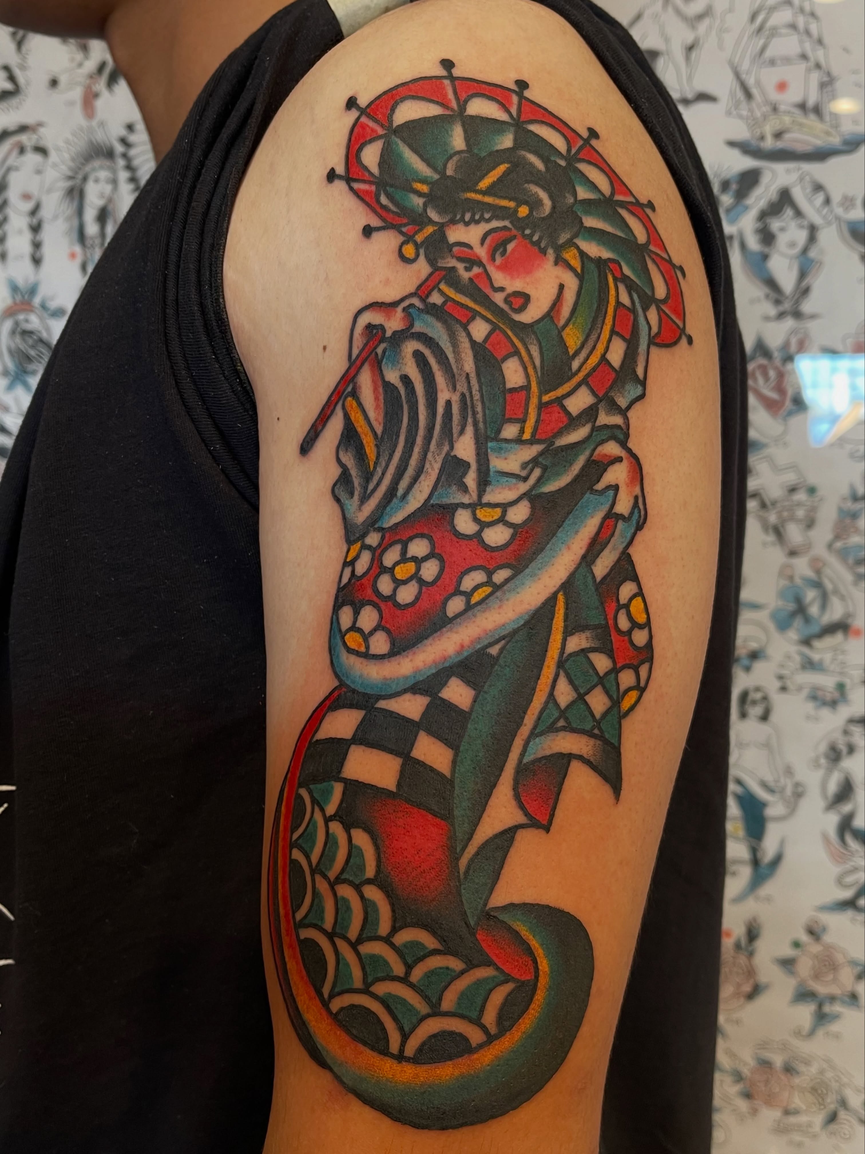 Geisha playing flute American traditional tattoo on the upper arm by Alex Garcia - Sac City Tattoo