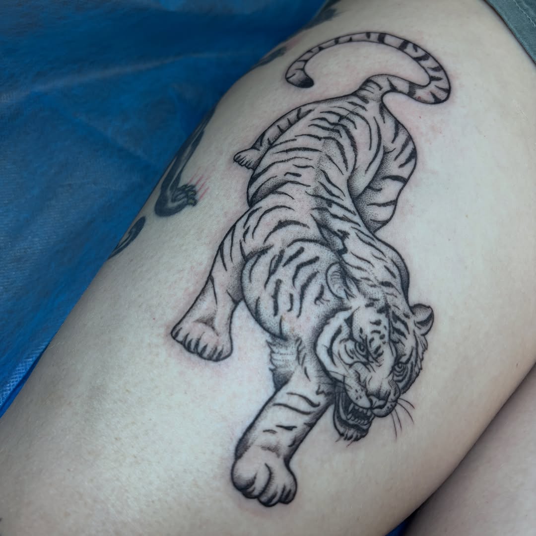 Tiger black and grey tattoo on the thigh by Sydney Gallucci