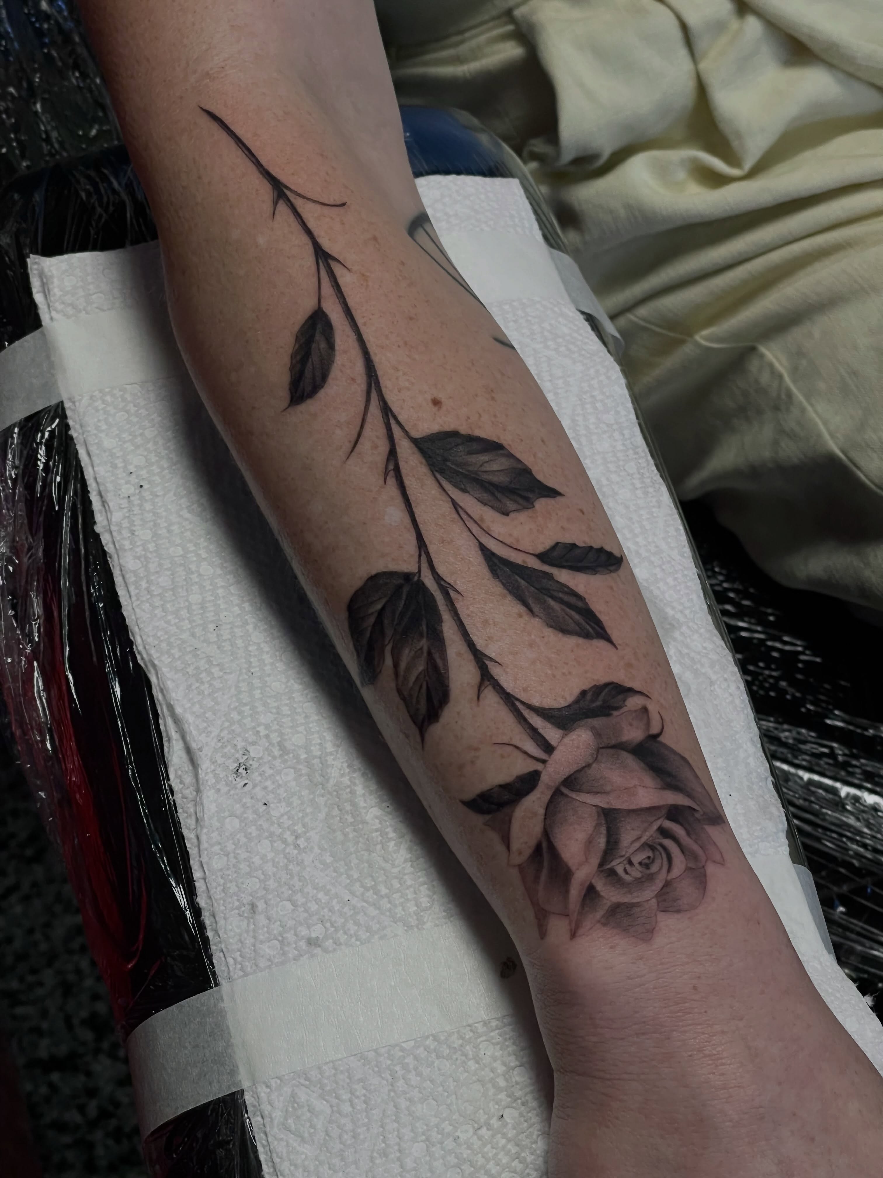 Rose and leaves black and grey tattoo on the forearm by Jonathan Red