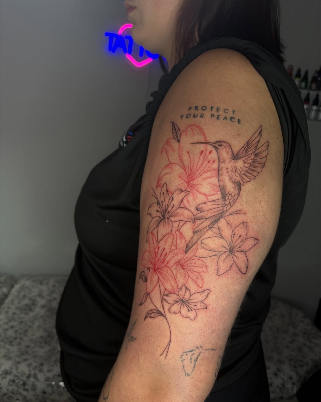 Hummingbird and flowers realism tattoo on the upper arm by @tattoosbyskyeee