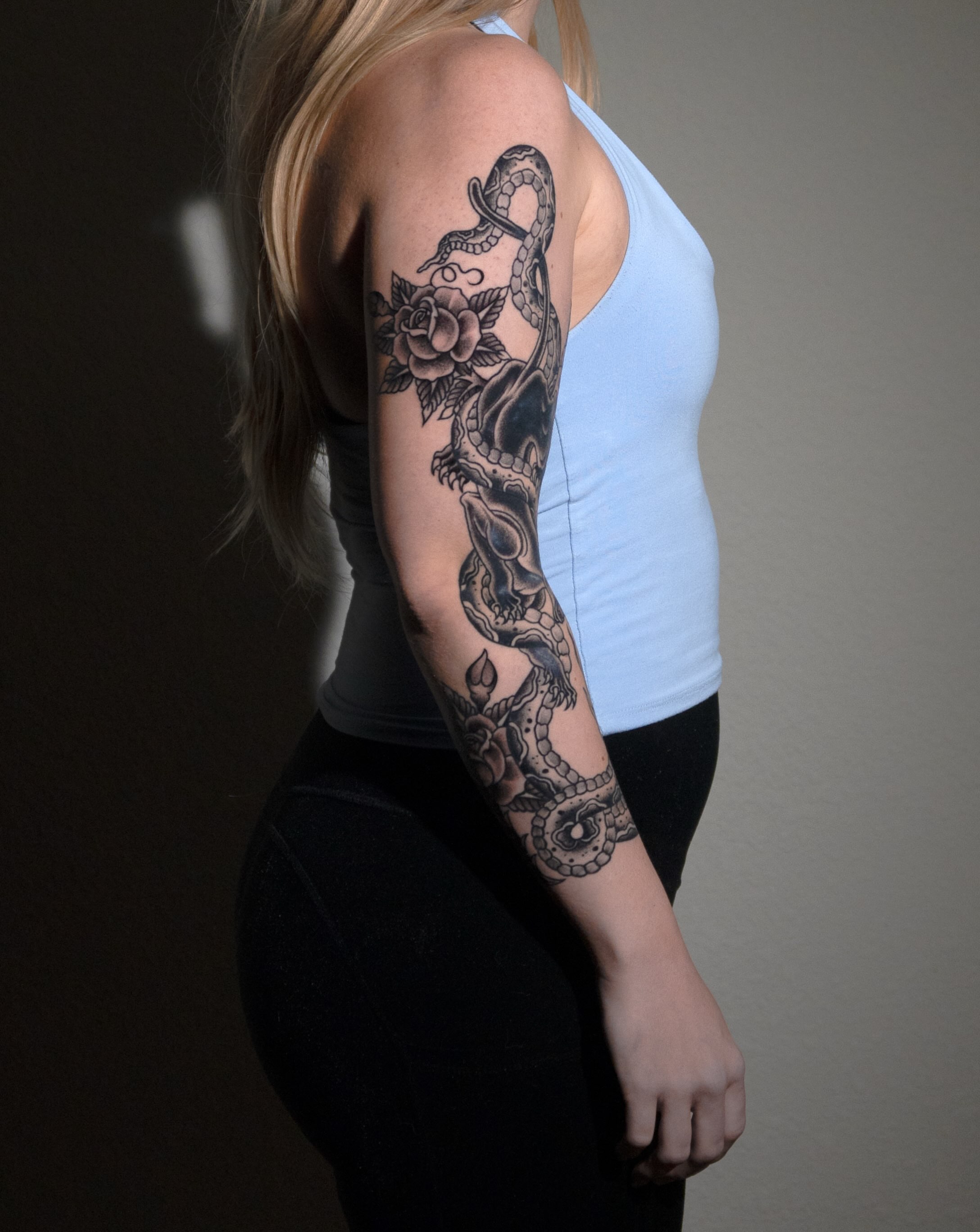 Snake and roses black and grey tattoo on the upper arm by Danny Pando