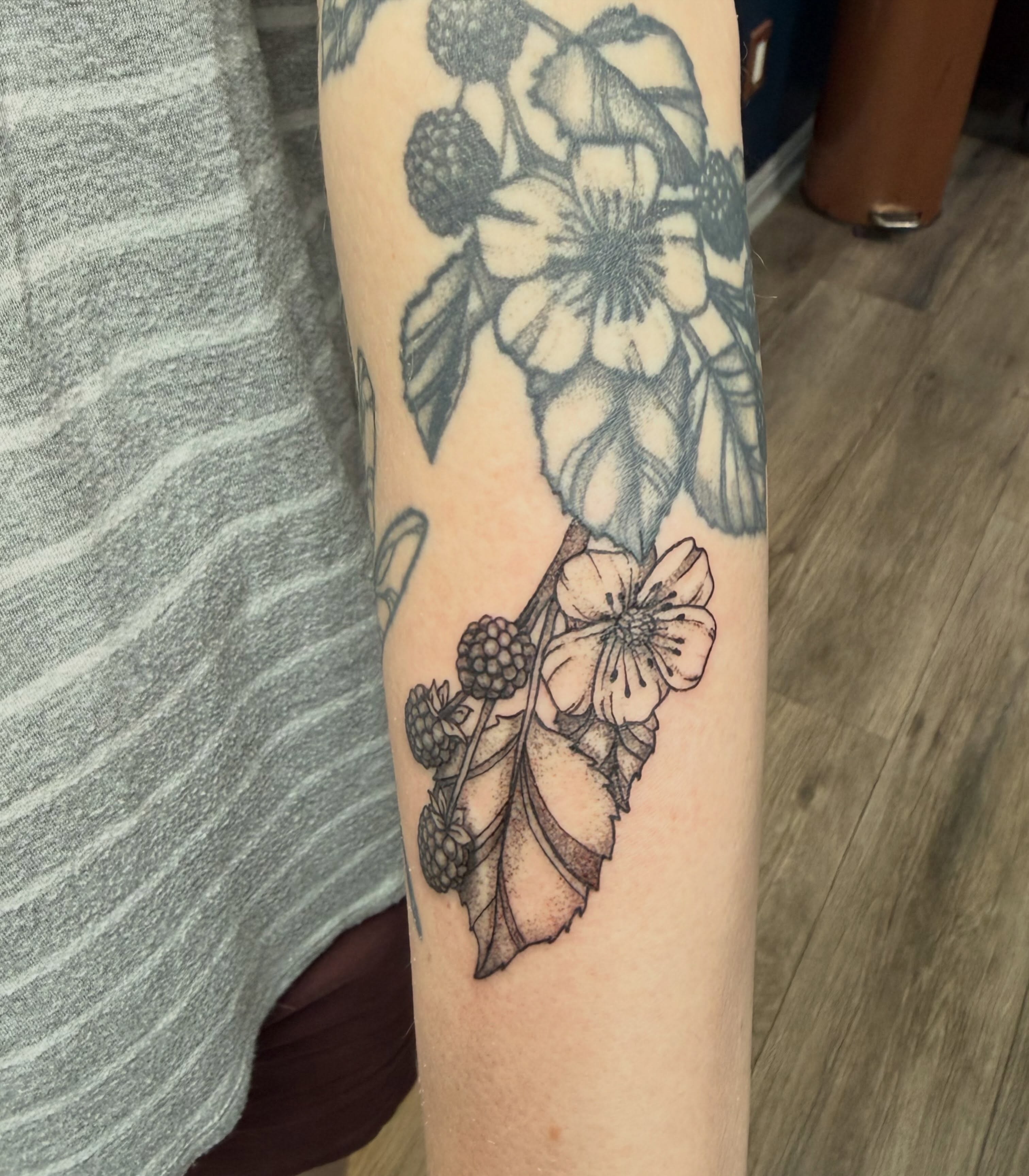 Flower and berries black and grey tattoo on the forearm by Elena
