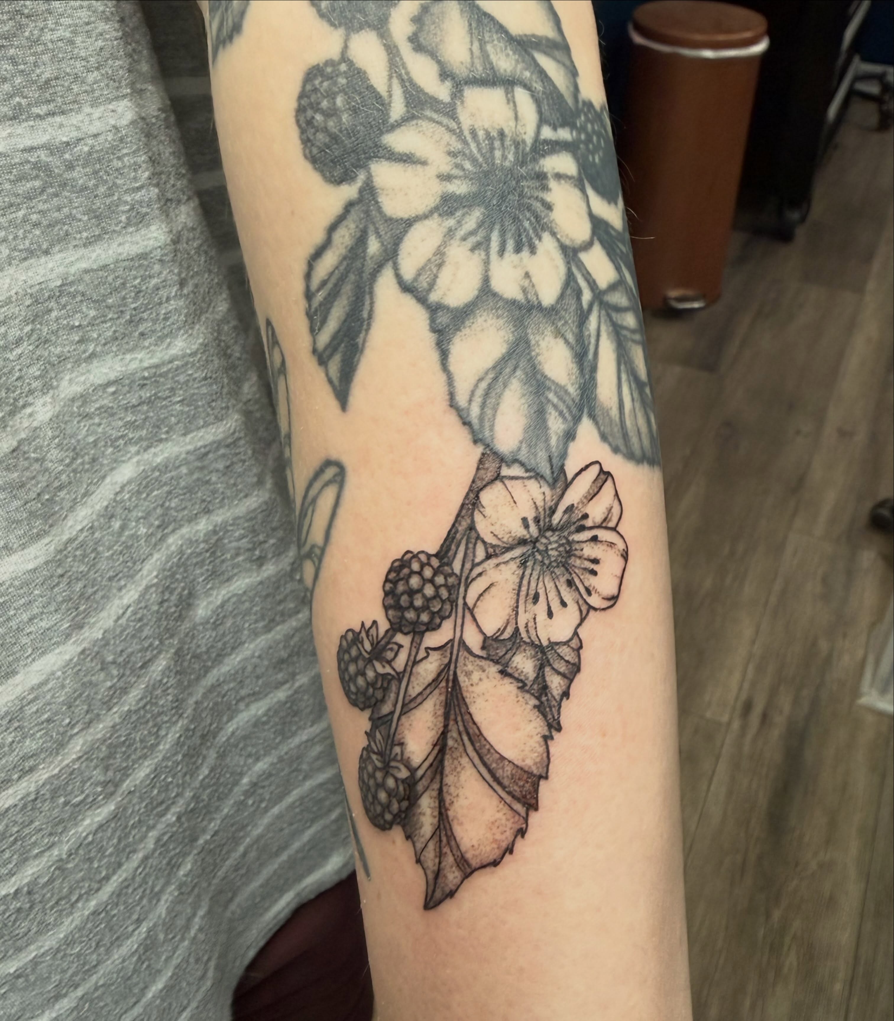 Flower and berries black and grey tattoo on the forearm by Elena