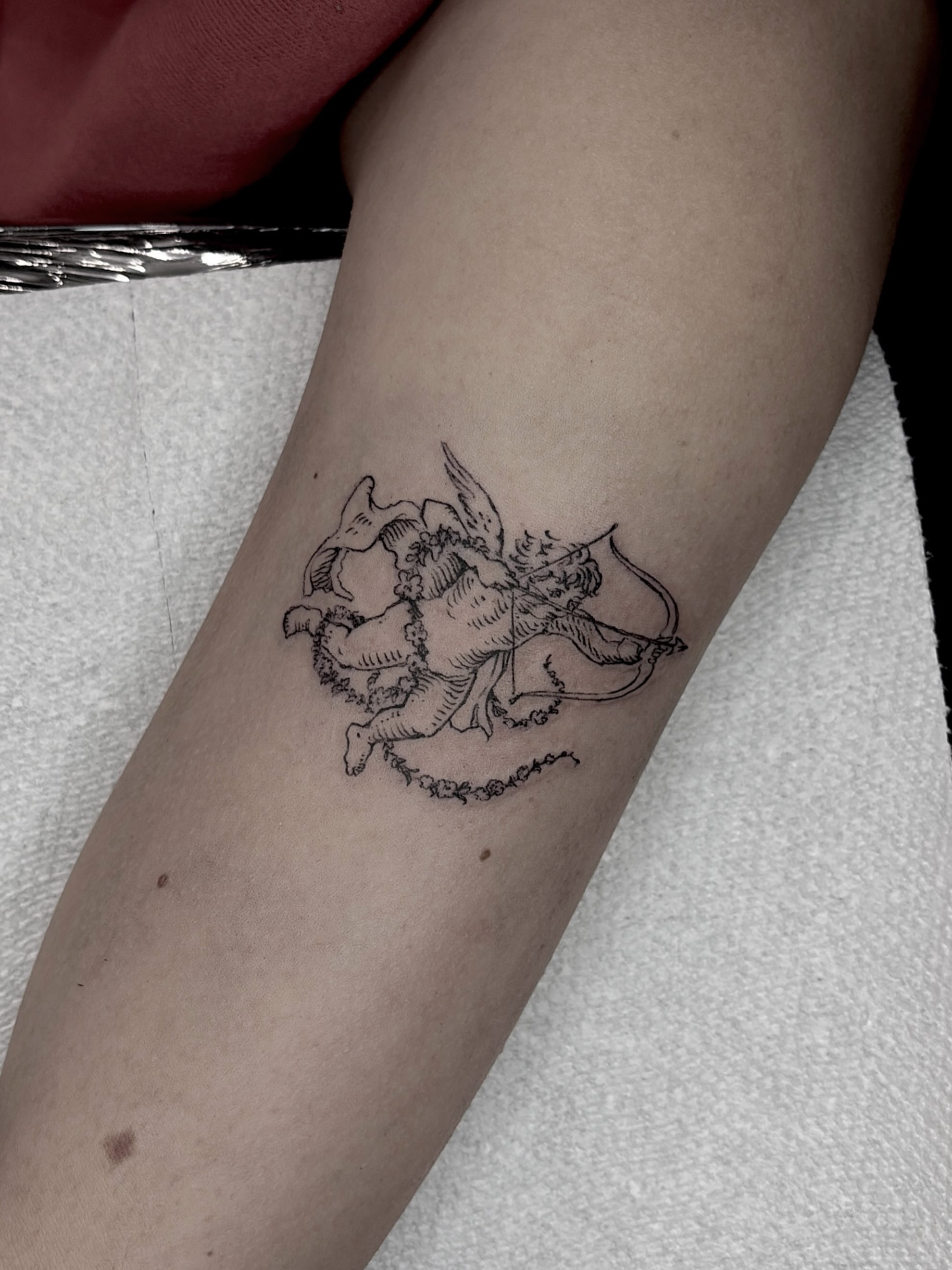 Cherub black and grey tattoo on the forearm by Harlee Hornsby