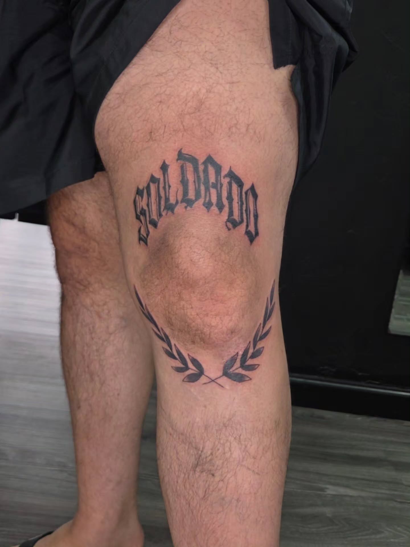 Soldado lettering script tattoo on the thigh by Jessica Duggan