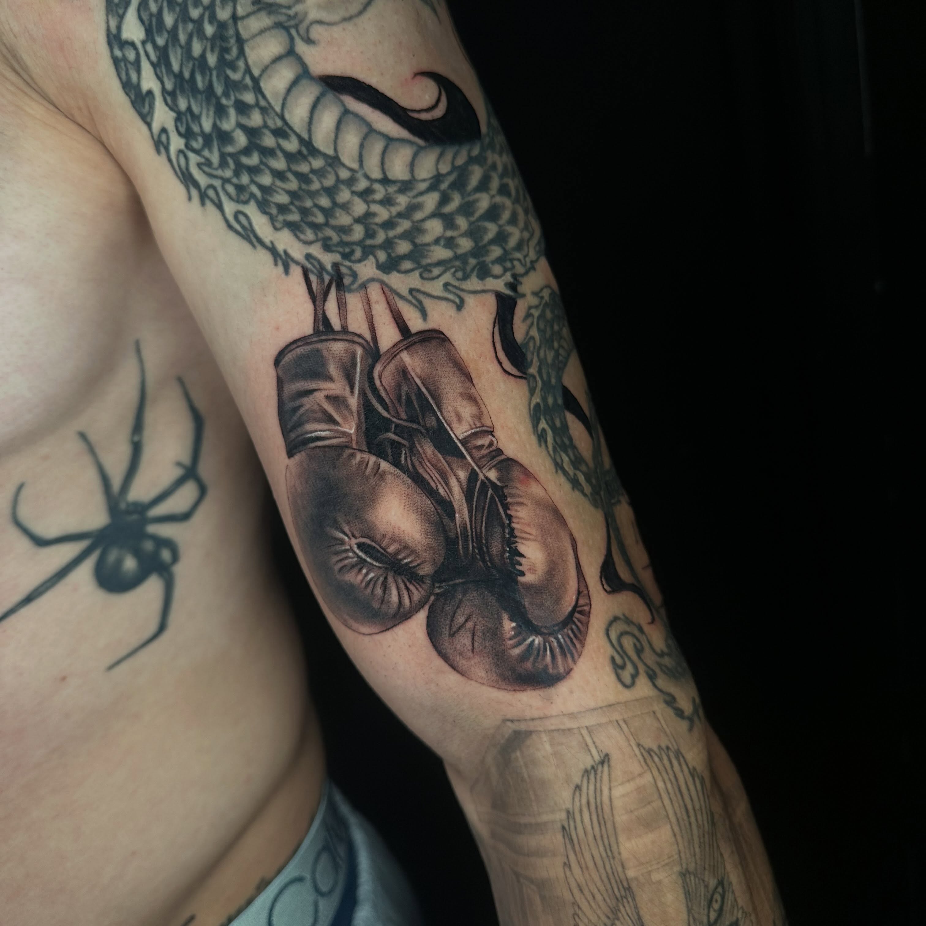 Boxing gloves and dragon realism tattoo on the forearm by Angela Azure