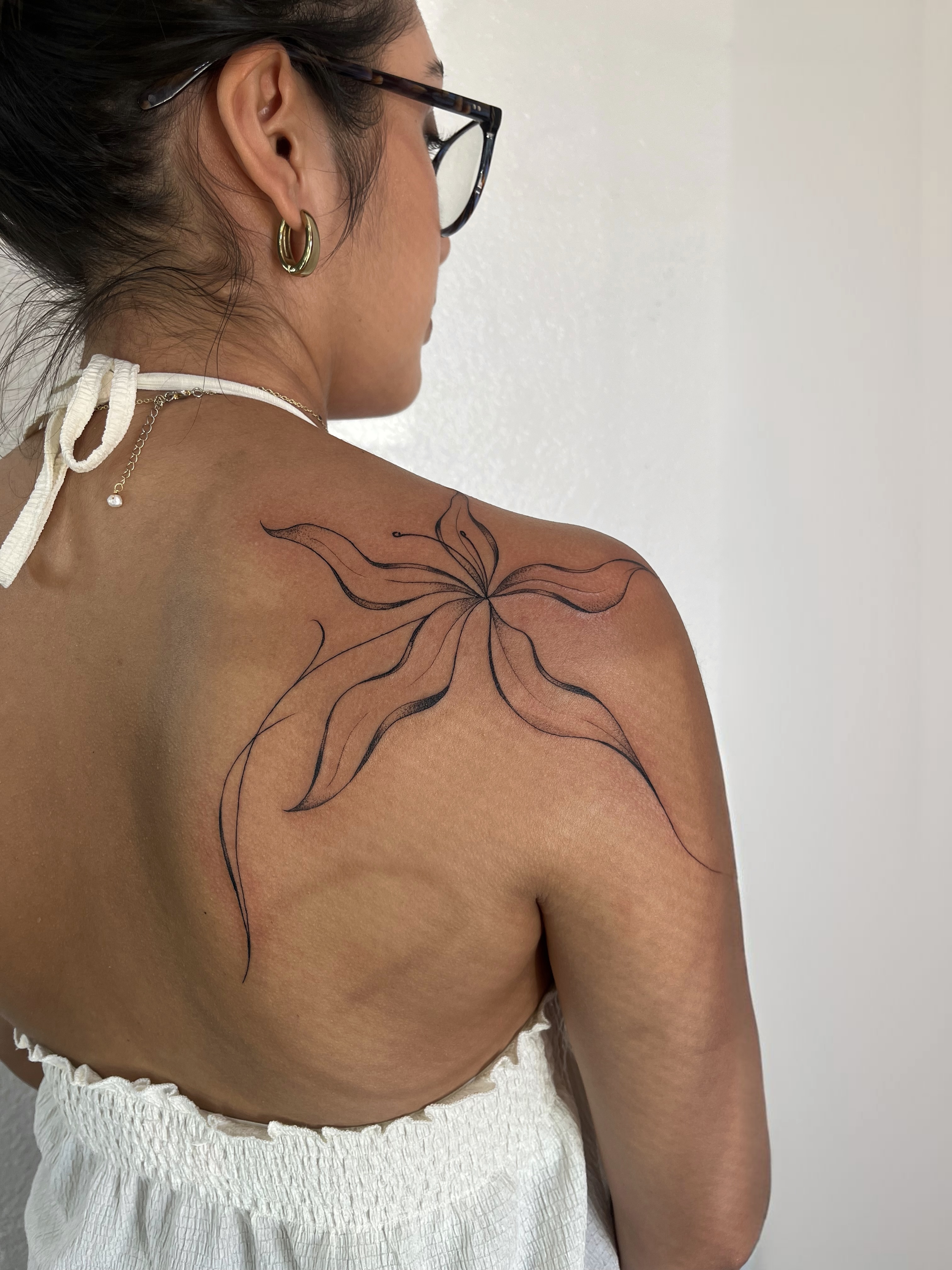 Flower black and grey tattoo on the shoulder by Sara Atamian, San Diego, California