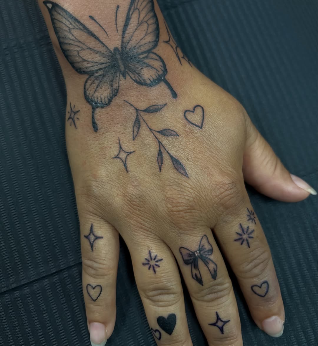 Butterfly and hearts black and grey tattoo on the hand by 𝕶𝕬𝕿