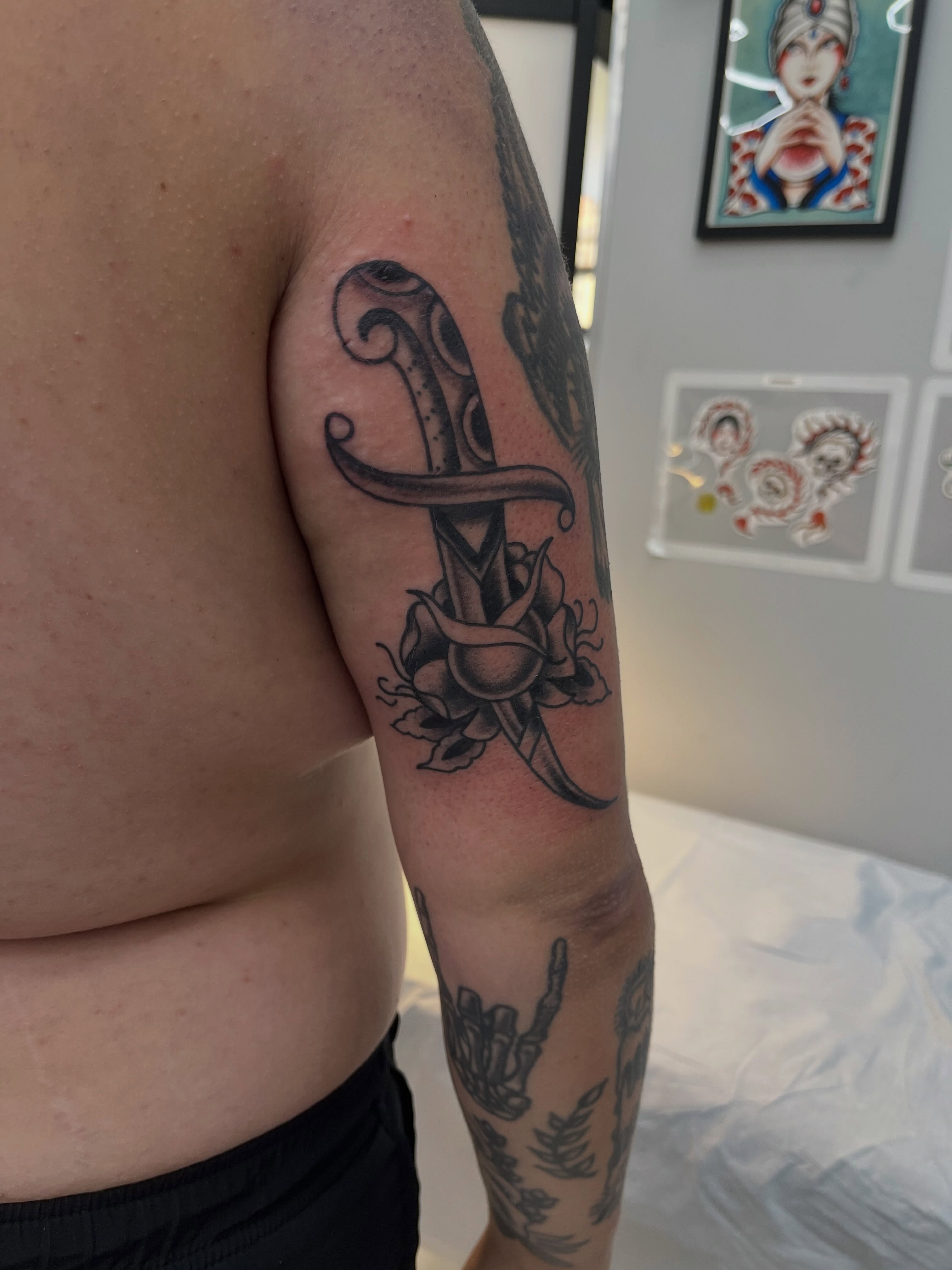 Knife and rose black and grey tattoo on the upper arm by Sour Tattoo, Somerville, Massachusetts