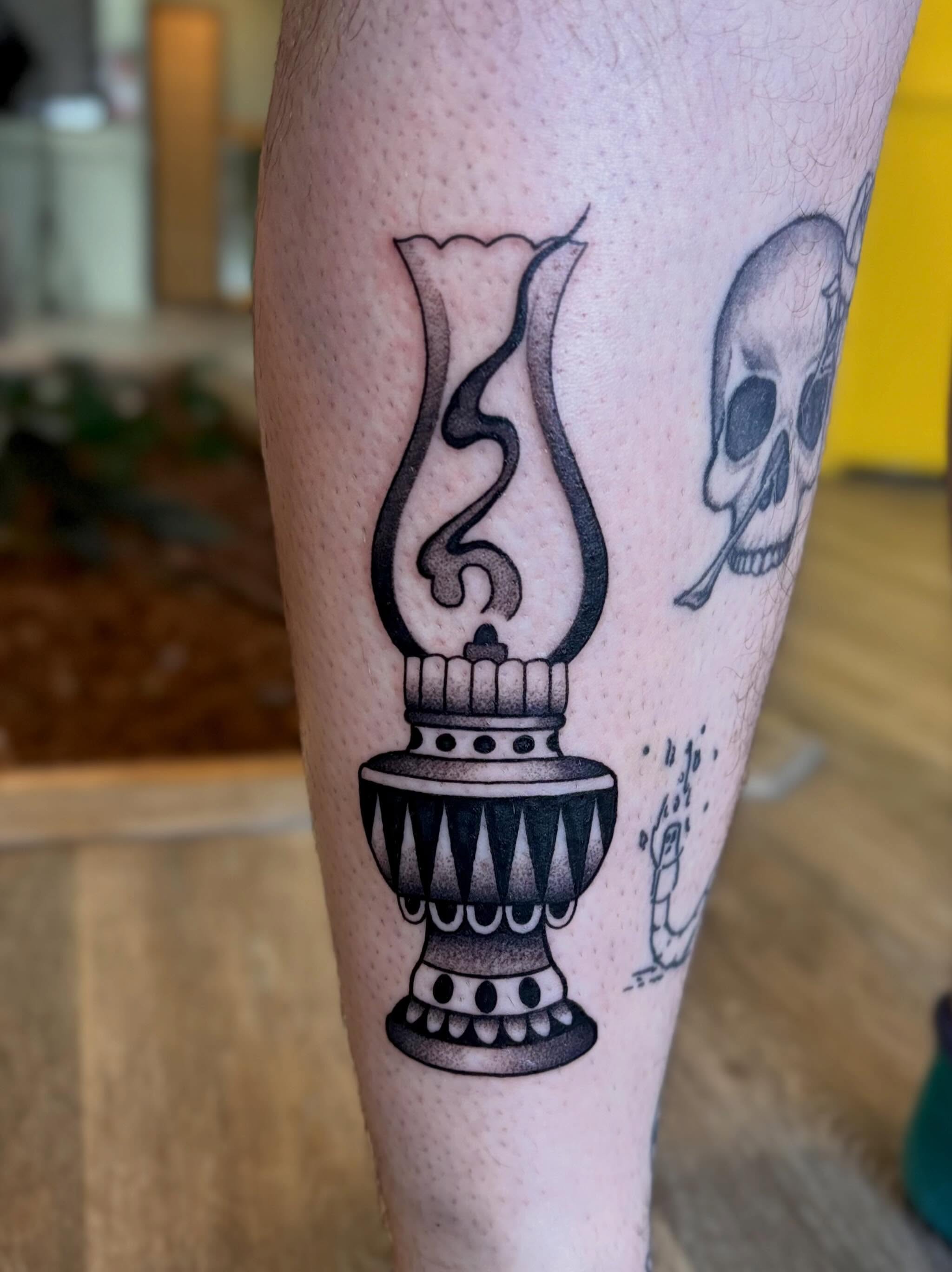 Oil lamp black and grey tattoo on the leg by Erica McCullough