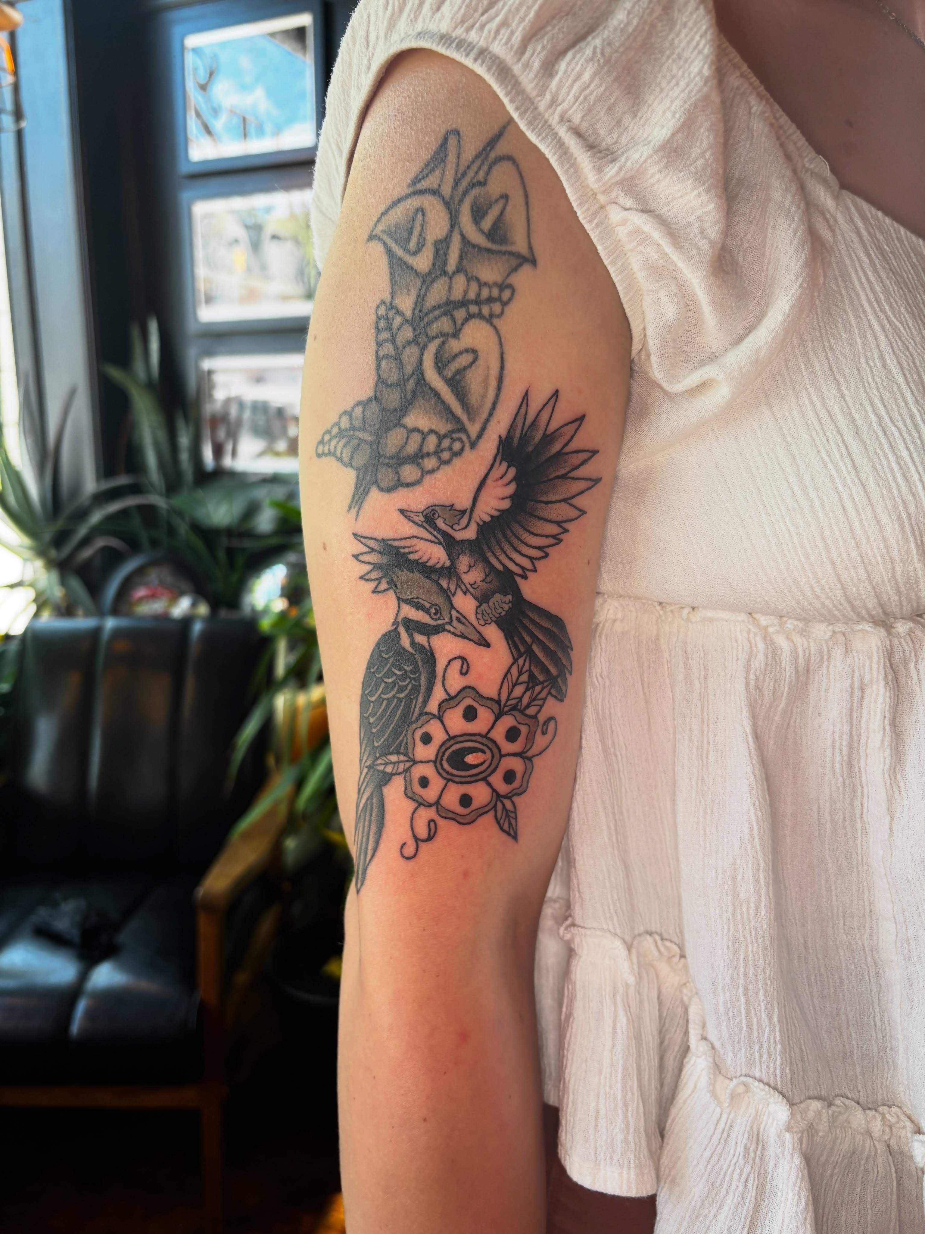 Bird and flowers black and grey tattoo on the forearm by Lilly Evans