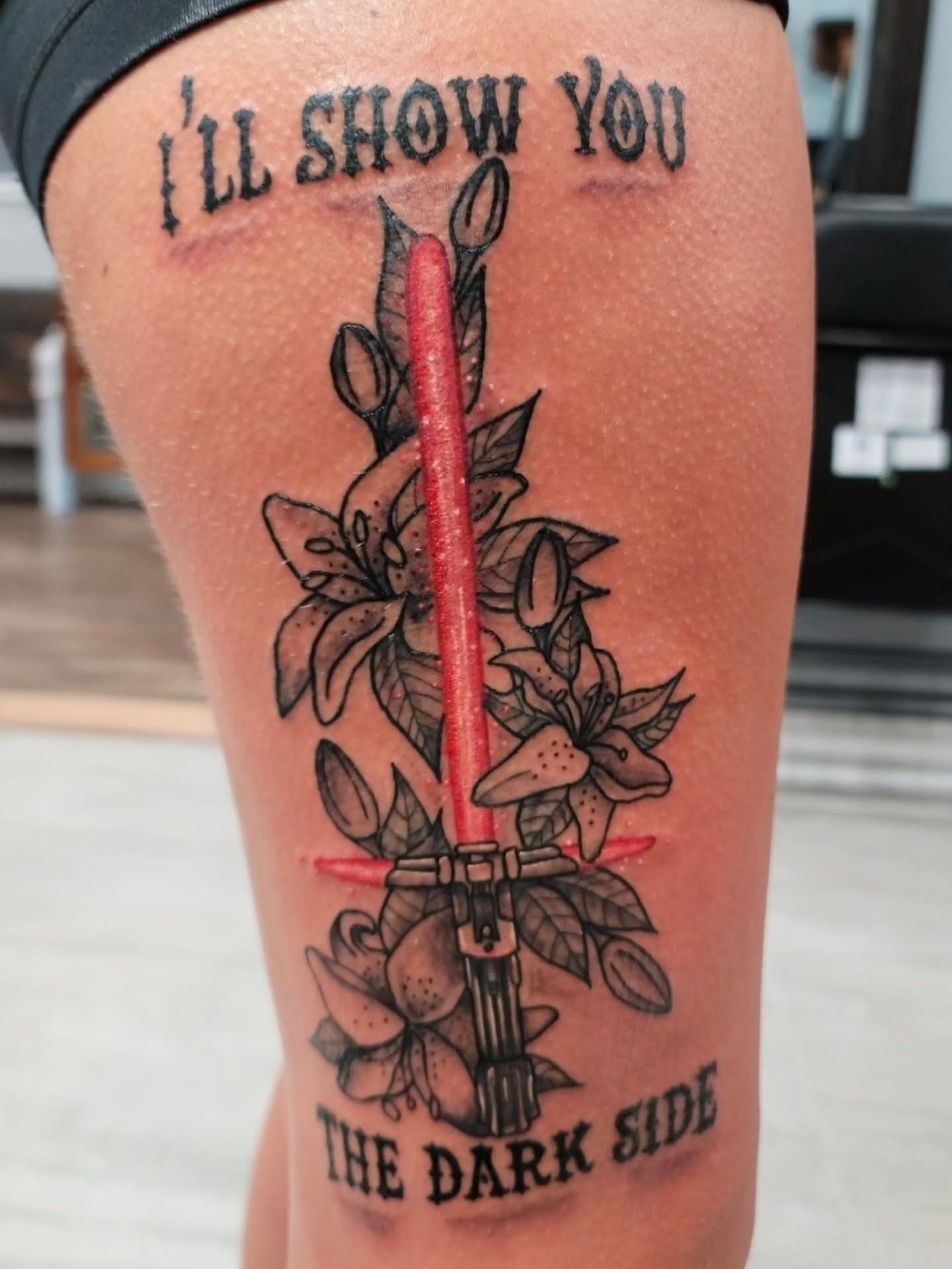 Lightsaber and flowers American traditional tattoo on the thigh by Captain Michael Devious