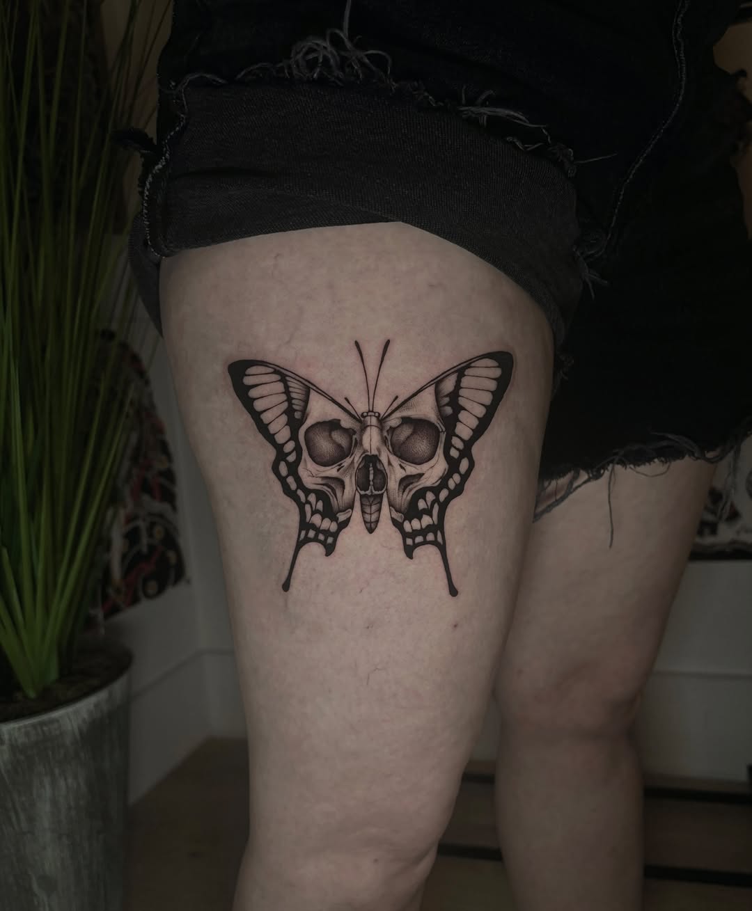 Skull butterfly realism tattoo on the thigh by Emma Cotter