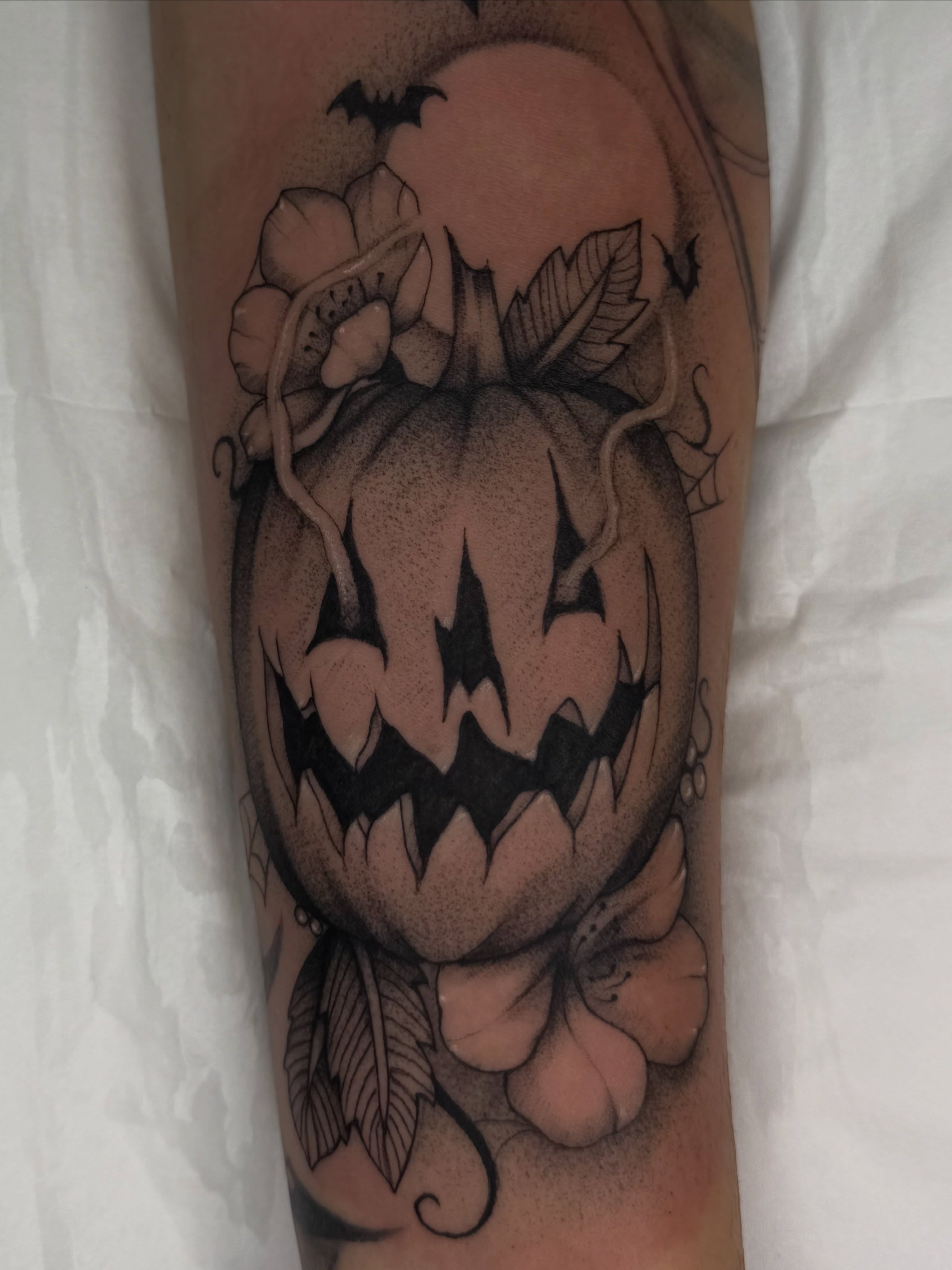 Jack-o'-lantern black and grey tattoo on the forearm by Halle Cooper