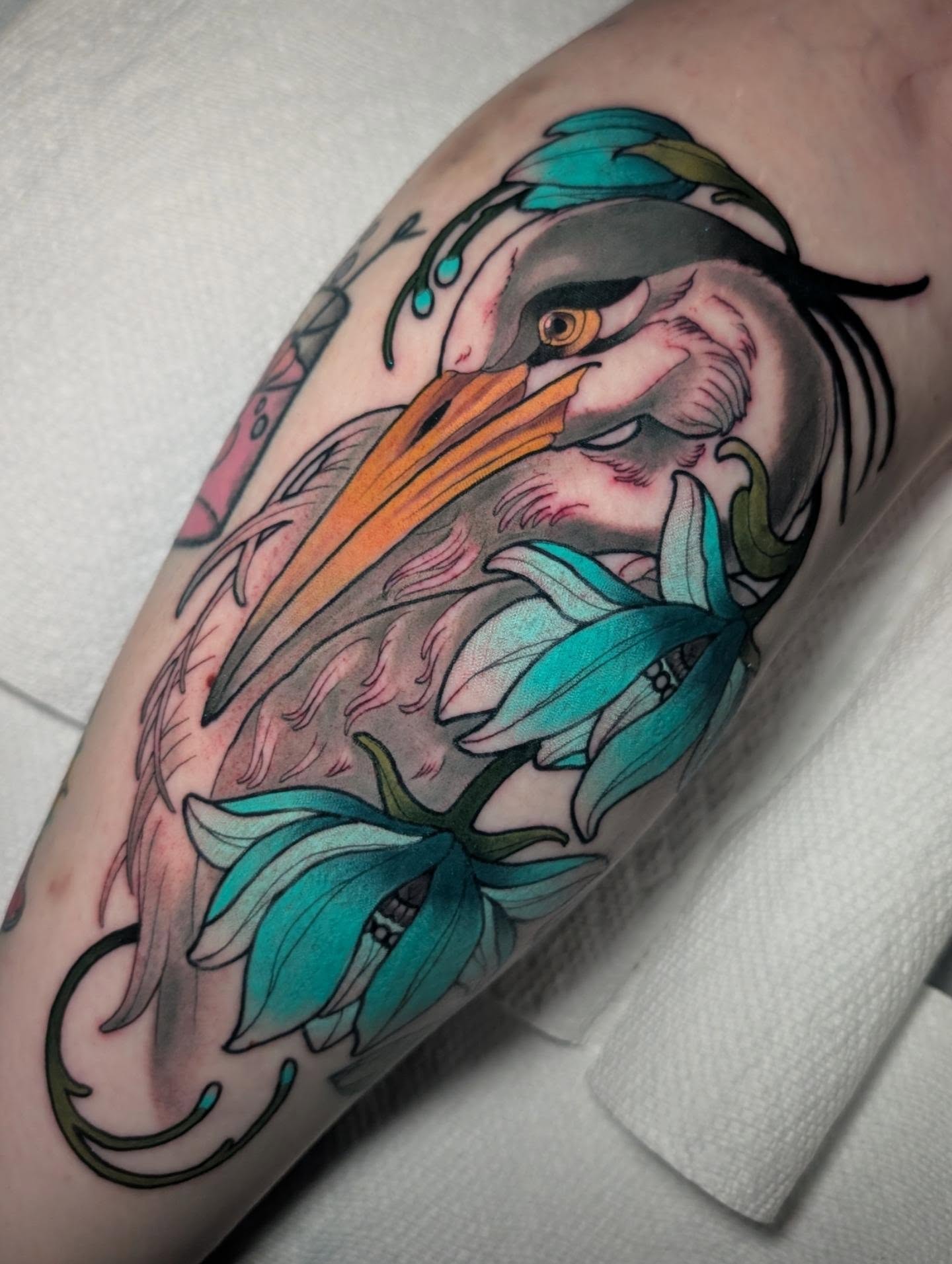 Heron and lily American traditional tattoo on the forearm by Ellie