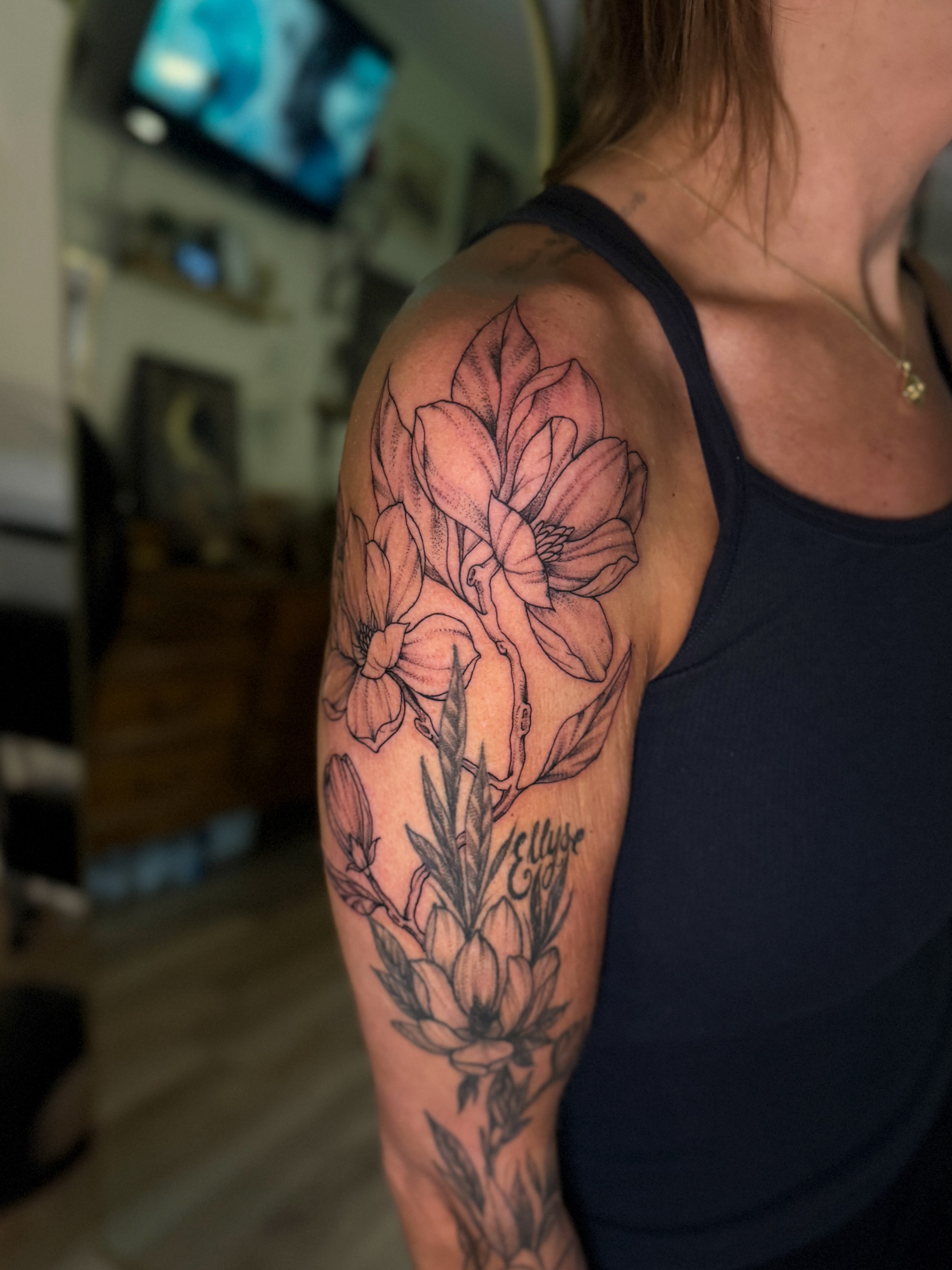 Flower bouquet black and grey tattoo on the upper arm by McKenna