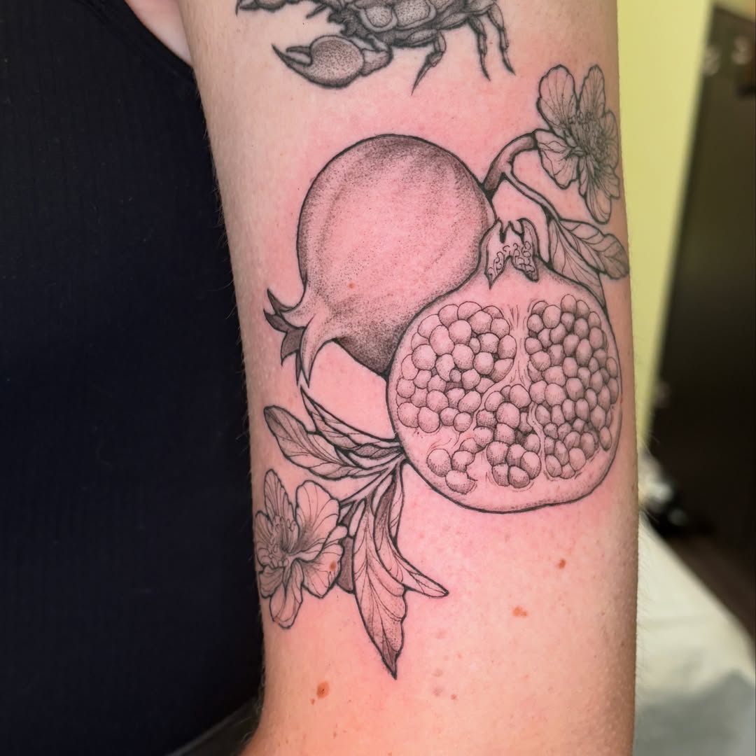 Pomegranate black and grey tattoo on the forearm by Chloe Shay