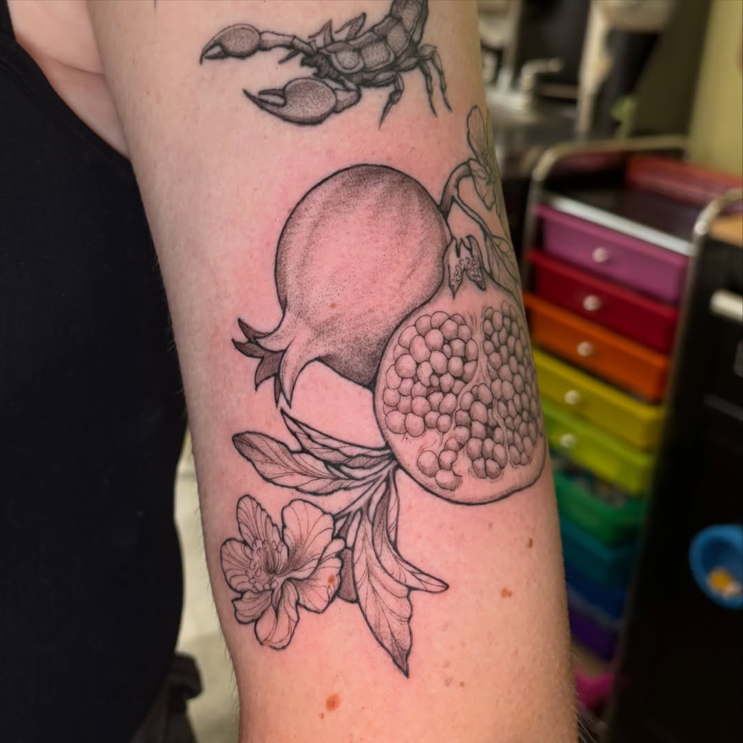 Pomegranate black and grey tattoo on the forearm by Chloe Shay