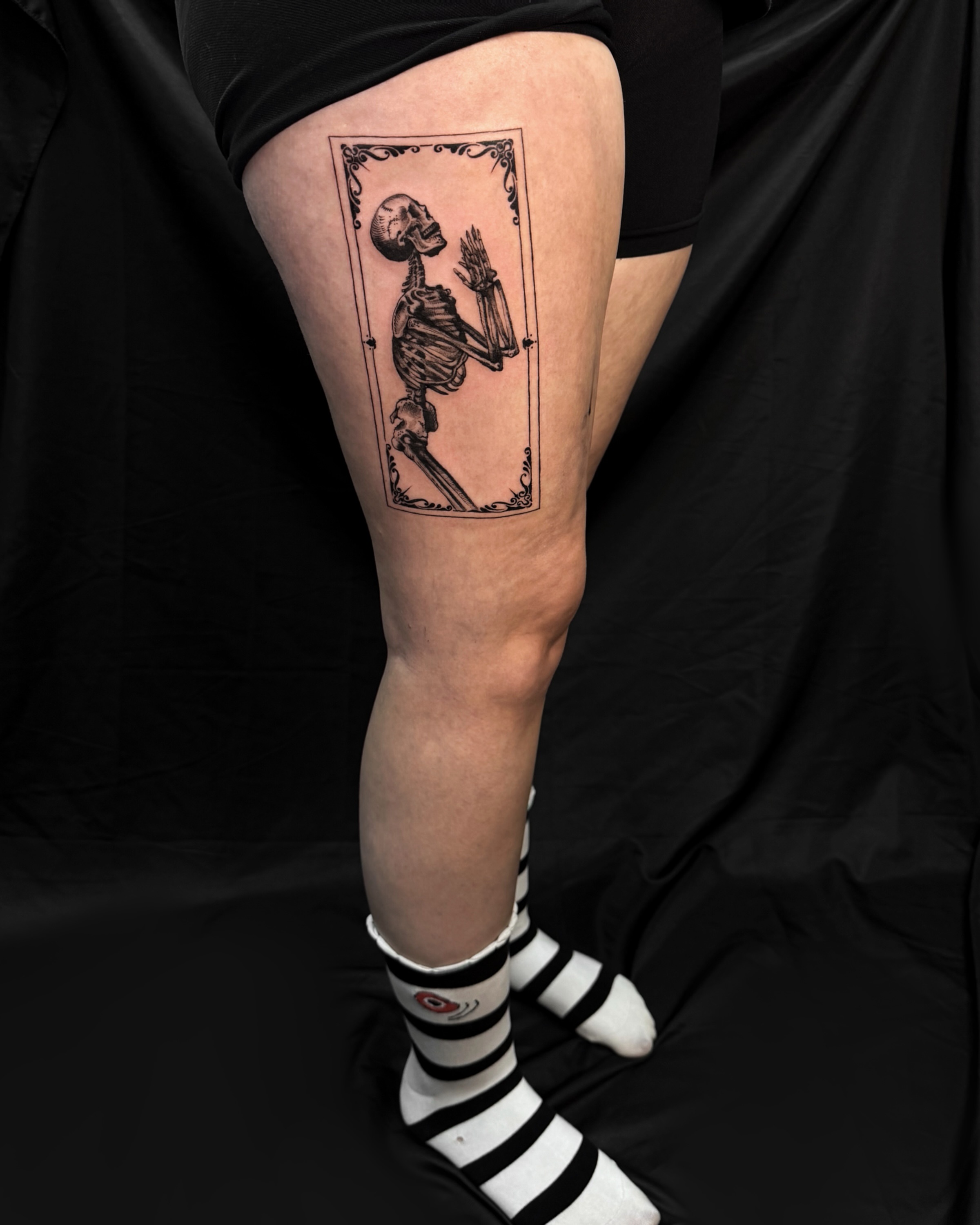 Skeleton holding wheat black and grey tattoo on the thigh by Sarah Deanna Derr
