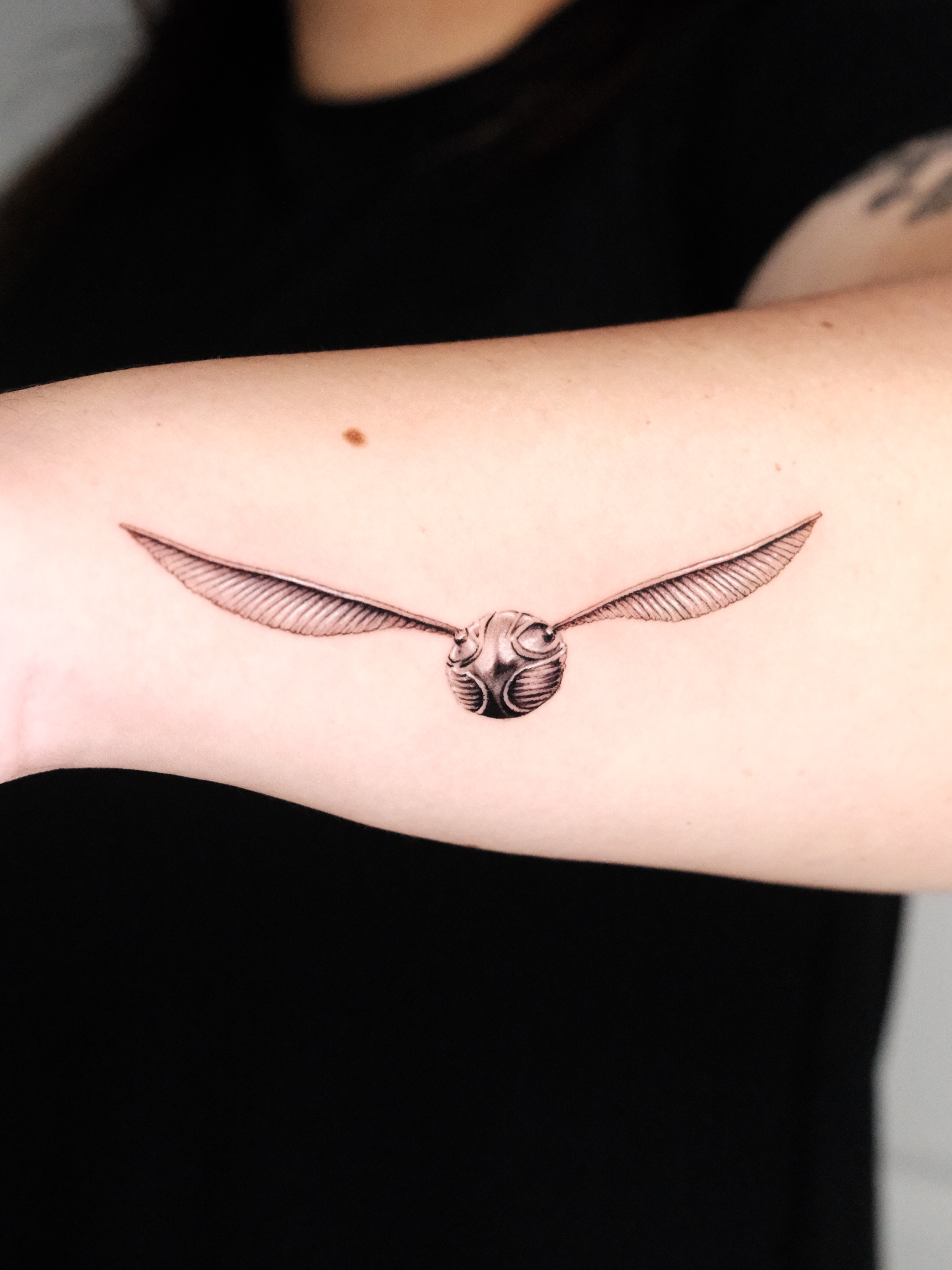 Golden snitch black and grey tattoo on the forearm by Bay Area Tattoo Artist