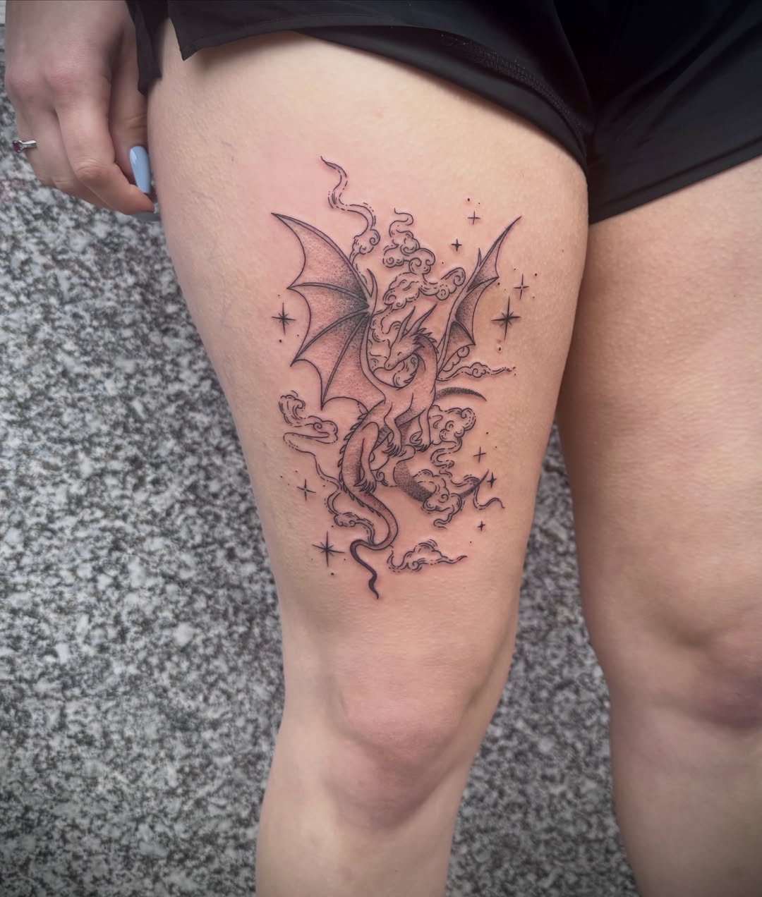 Dragon black and grey tattoo on the thigh by Kylie Allen