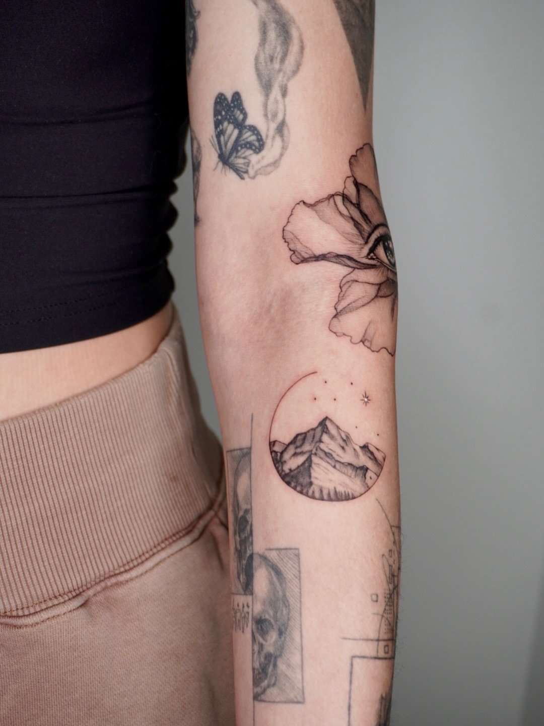 Flower and mountain realism tattoo on the forearm by Ashley Limon