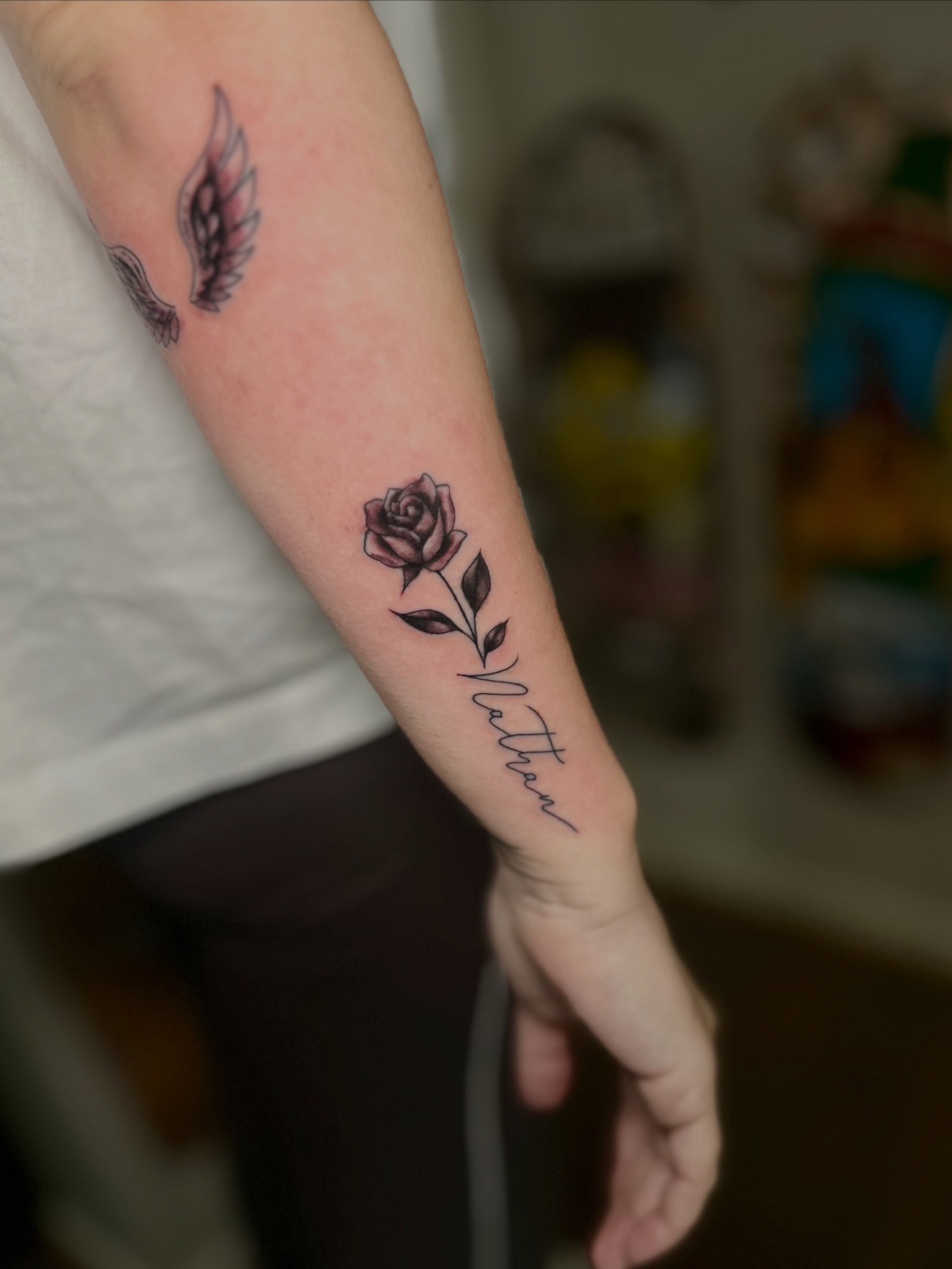 Rose with name black and grey tattoo on the forearm by @tatt2st