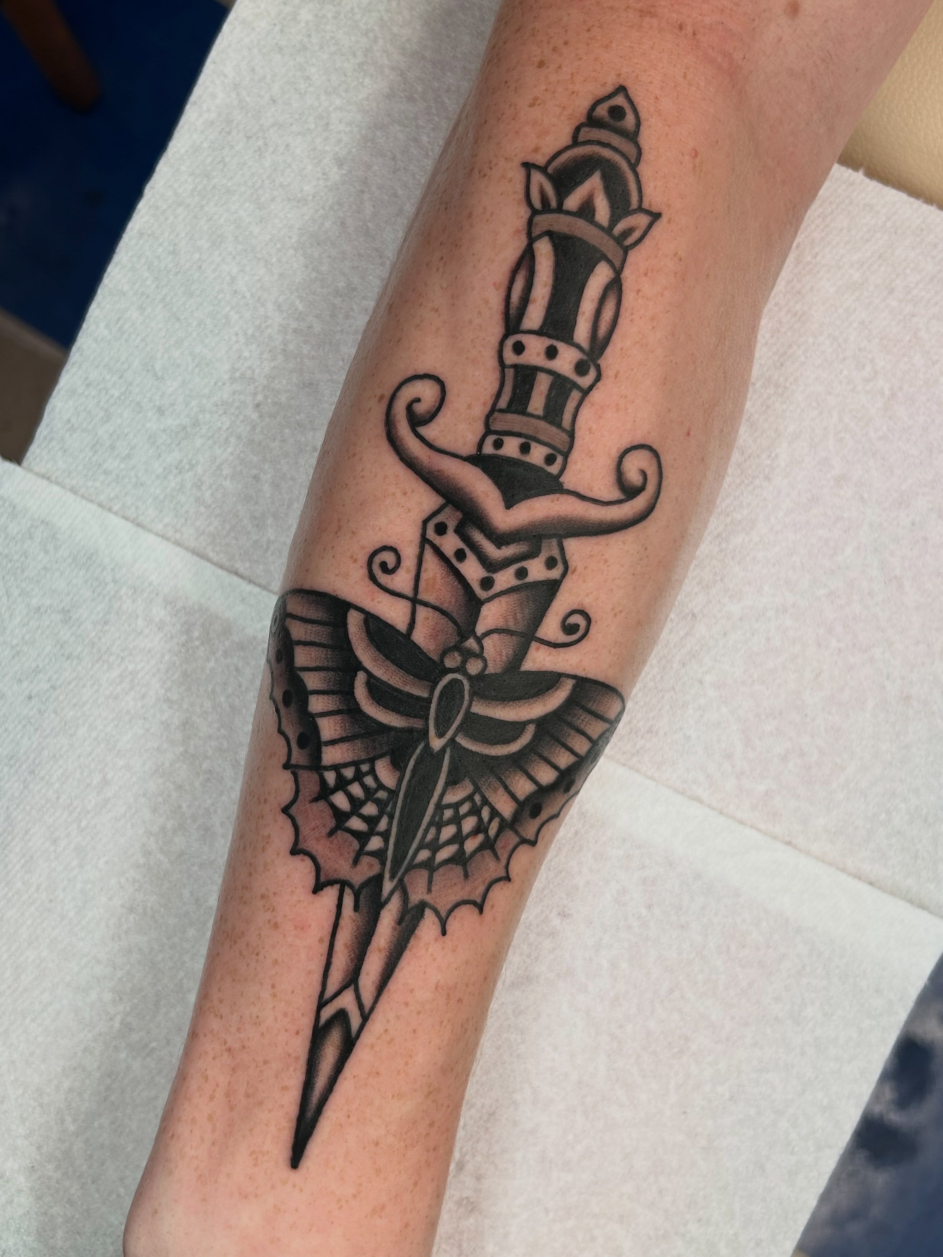 Knife with wings black and grey tattoo on the forearm by β π€ππ©π¦π©π’π β± β
