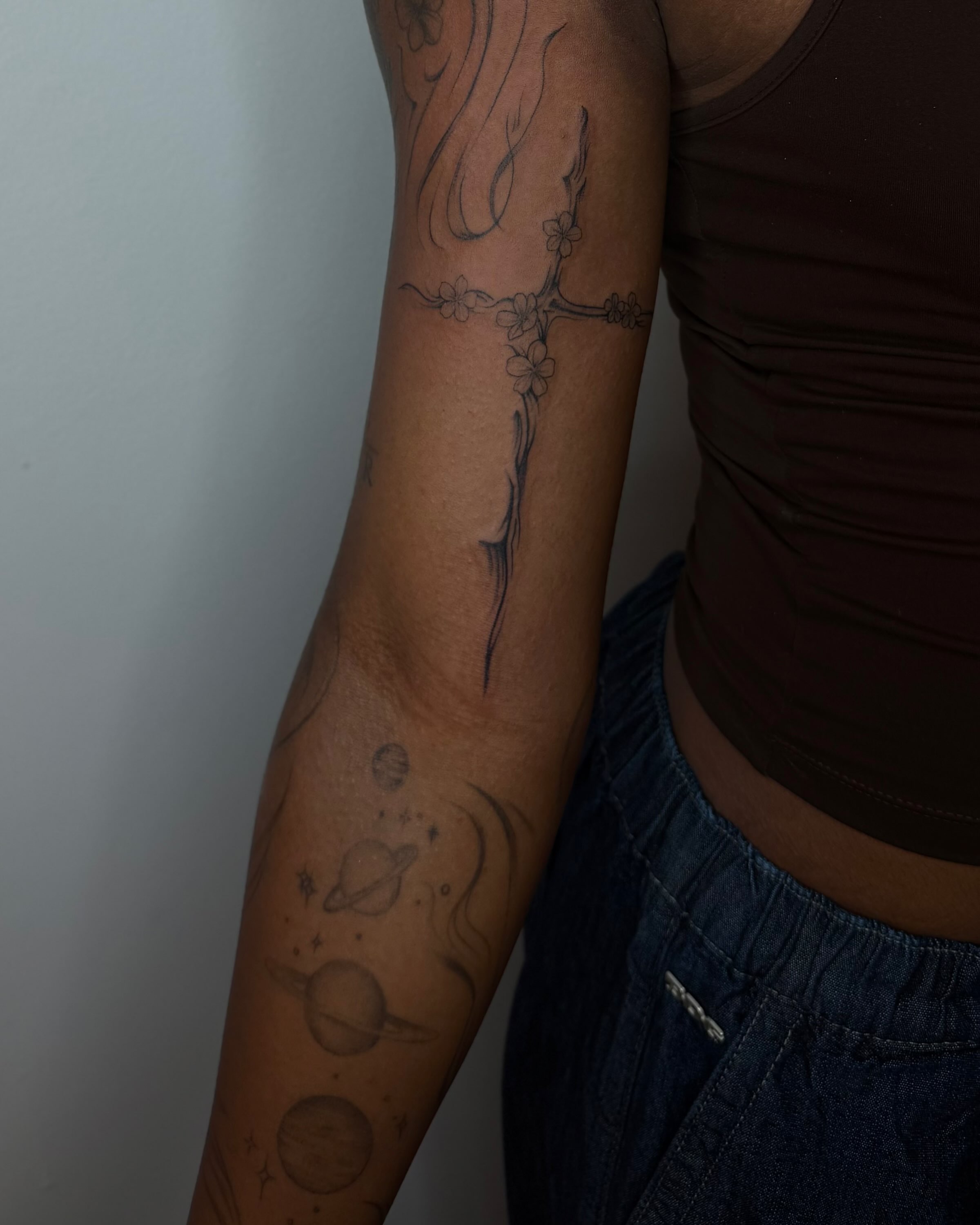 Cross with flowers black and grey tattoo on the forearm by Carson Mccullers ✨