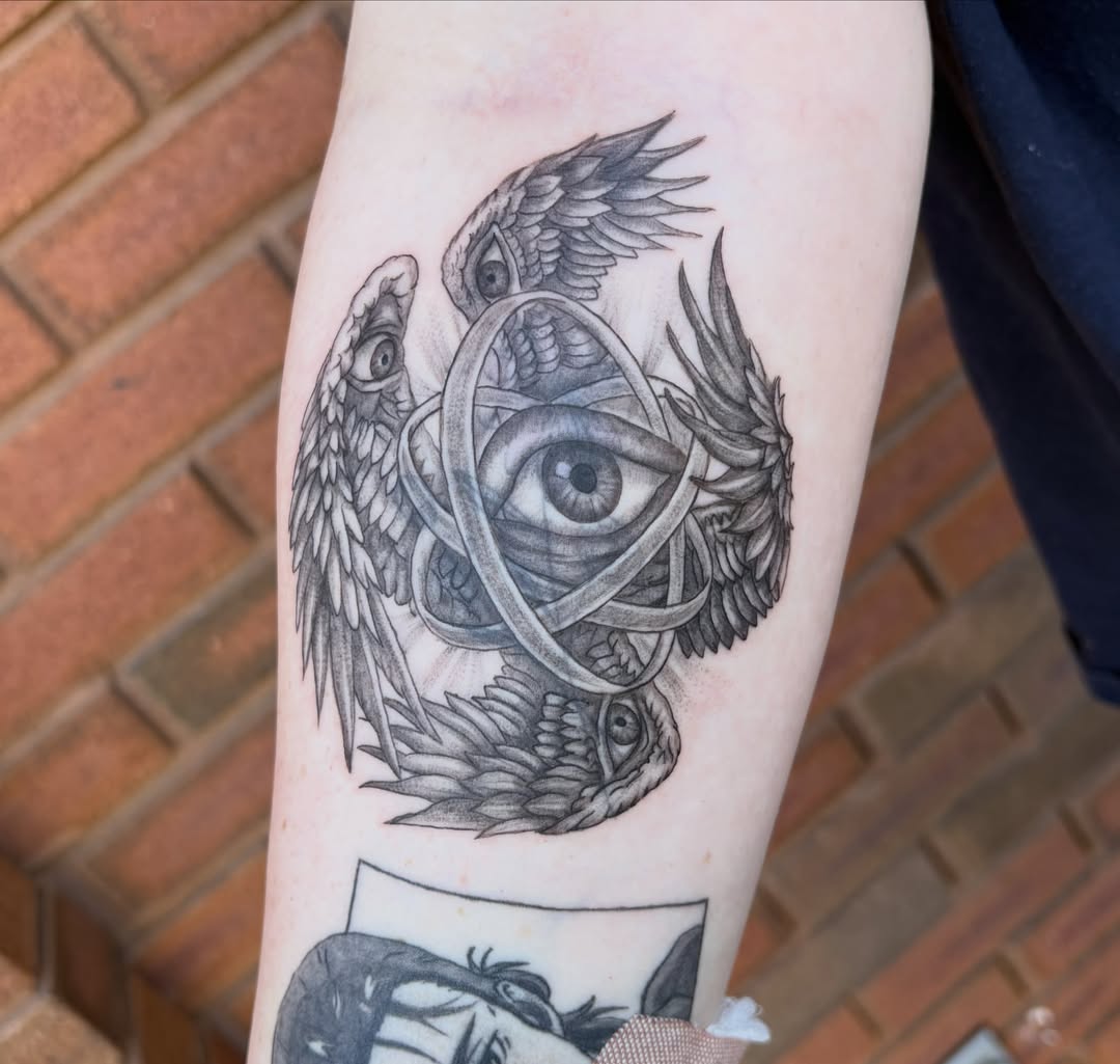 Eye with wings geometric tattoo on the forearm by Sierra Maynard