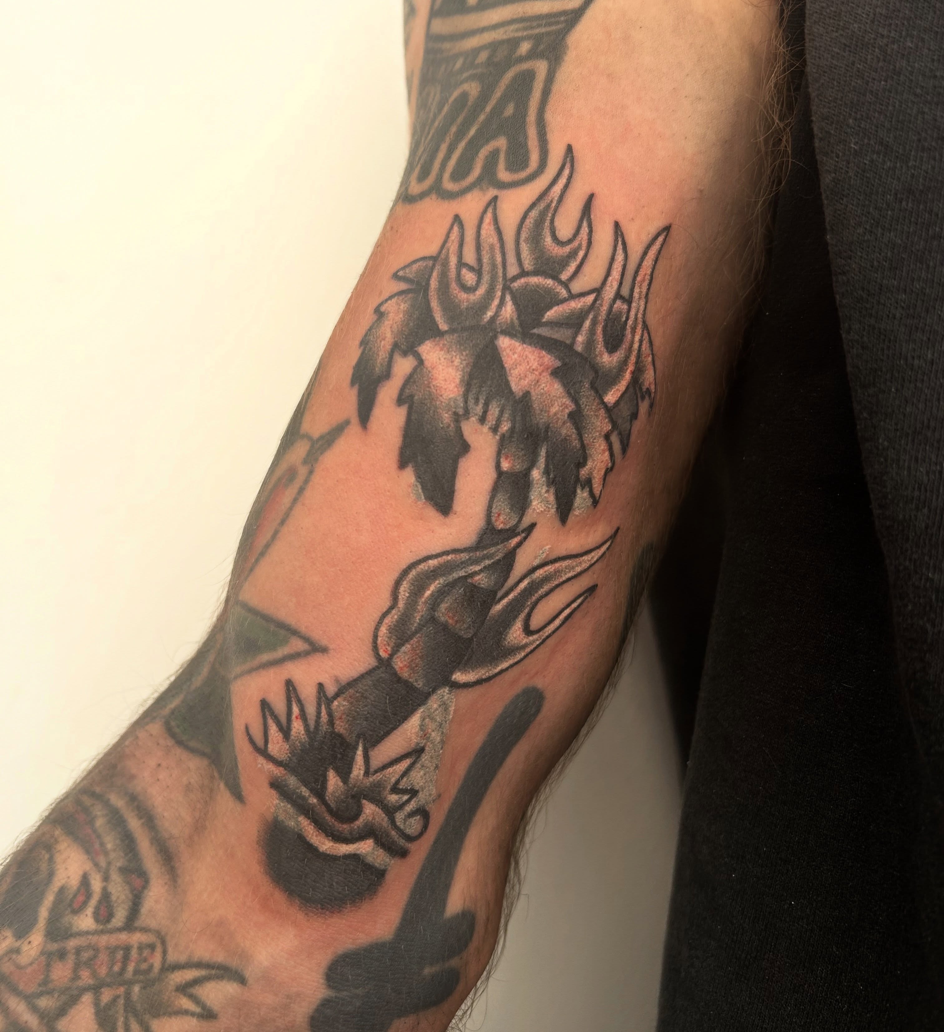 Flame and leaves American traditional tattoo on the forearm by Tawni Bender