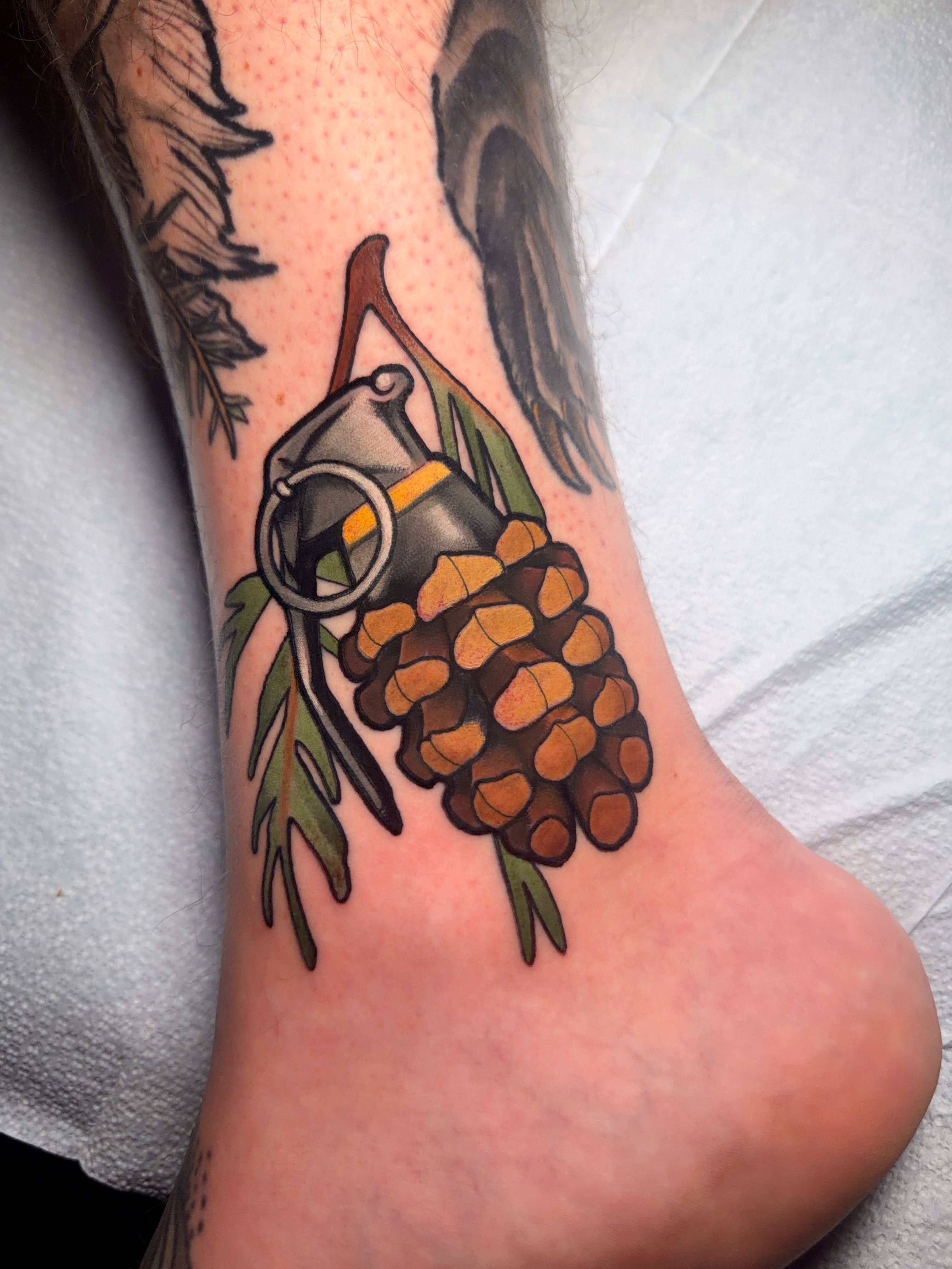 Pinecone and lantern American traditional tattoo on the foot by Milo Alfring Tattoo