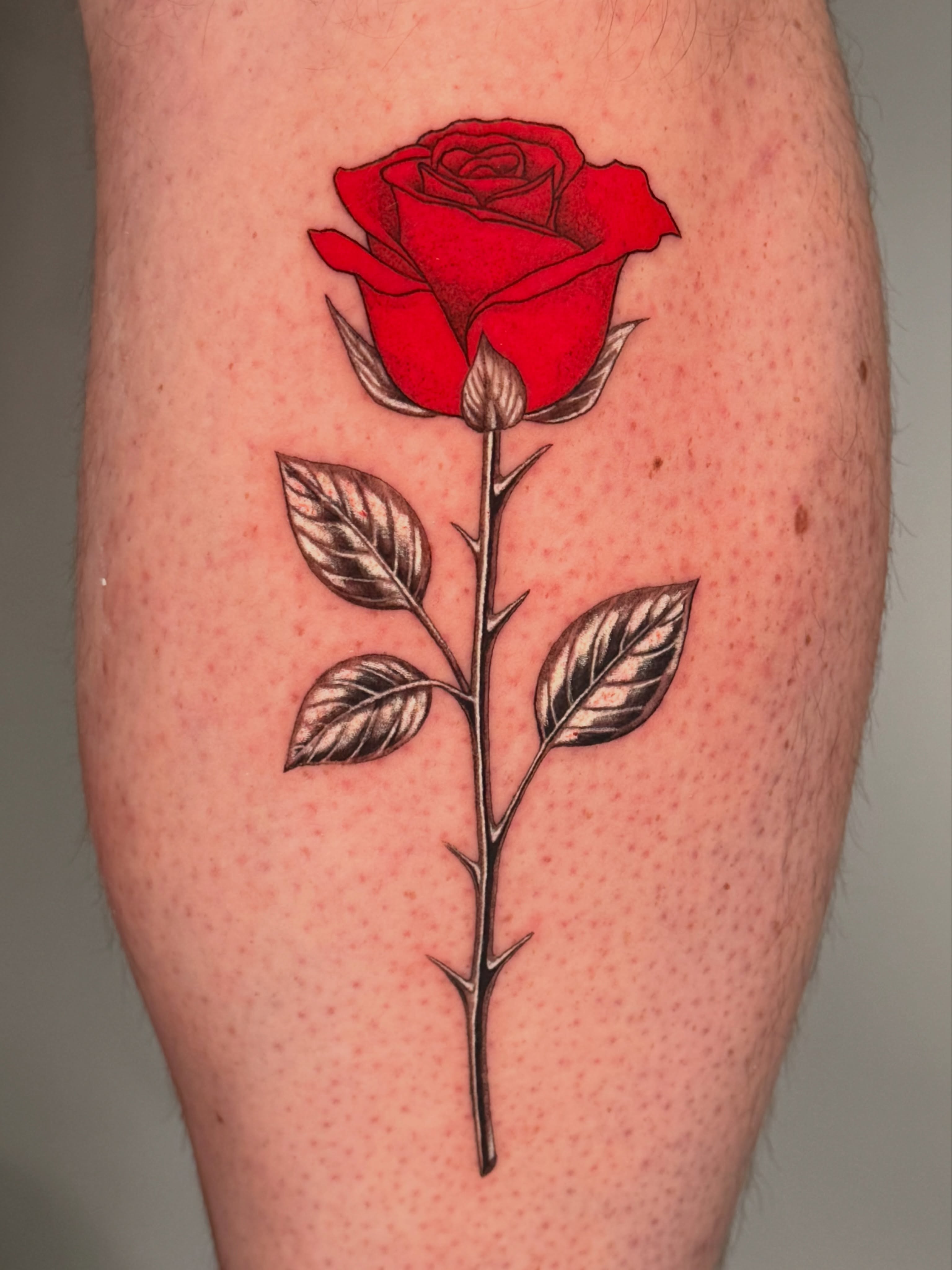Red rose realism tattoo on the leg by Jerm Lewis