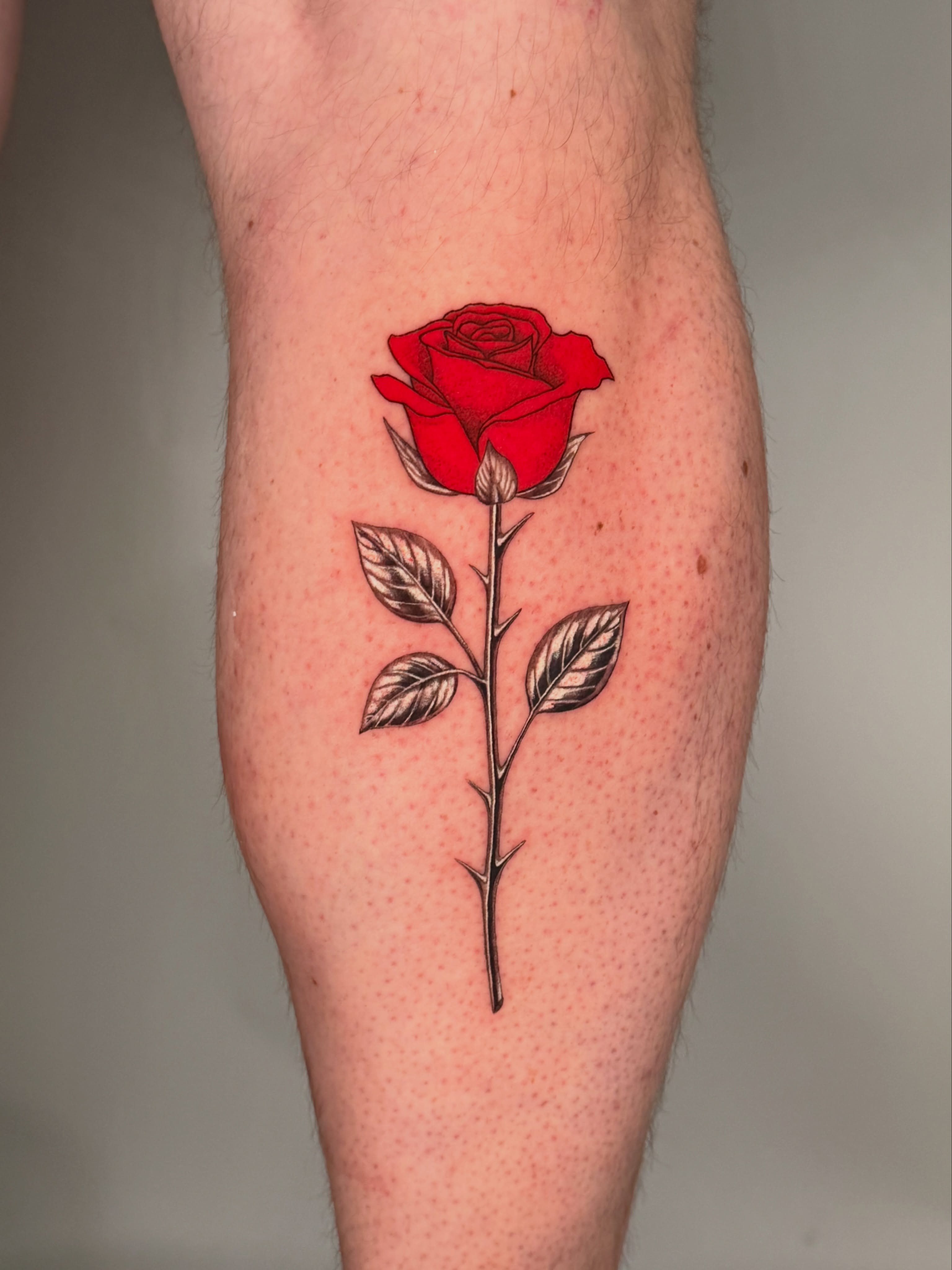 Red rose realism tattoo on the forearm by Jerm Lewis