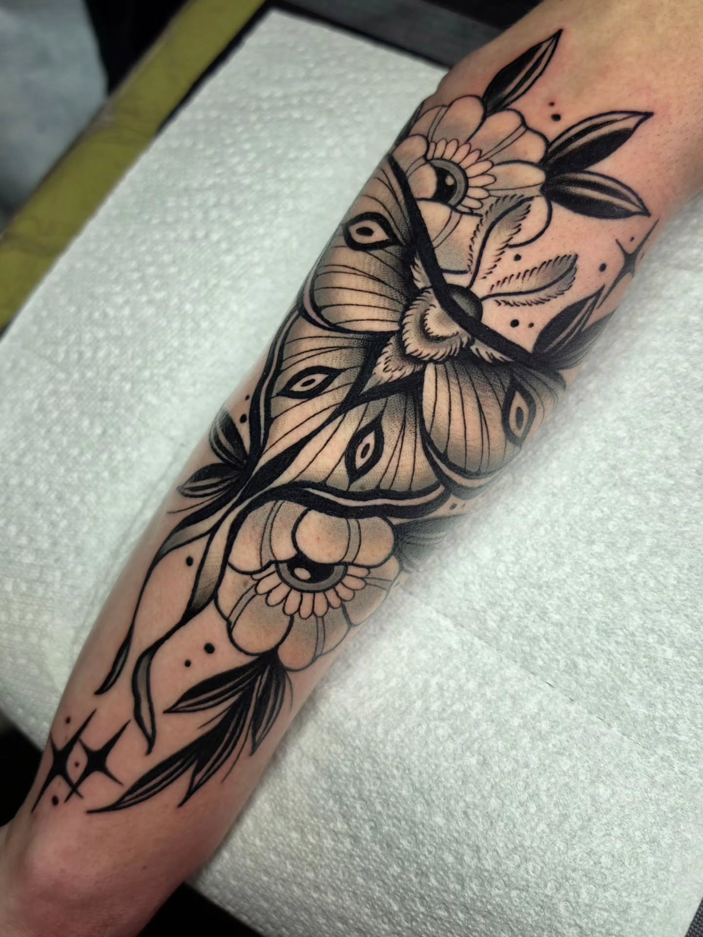 Peacock and floral American traditional tattoo on the forearm by 𝔎𝔦𝔯𝔞 𝔅𝔦𝔰𝔥𝔬𝔭
