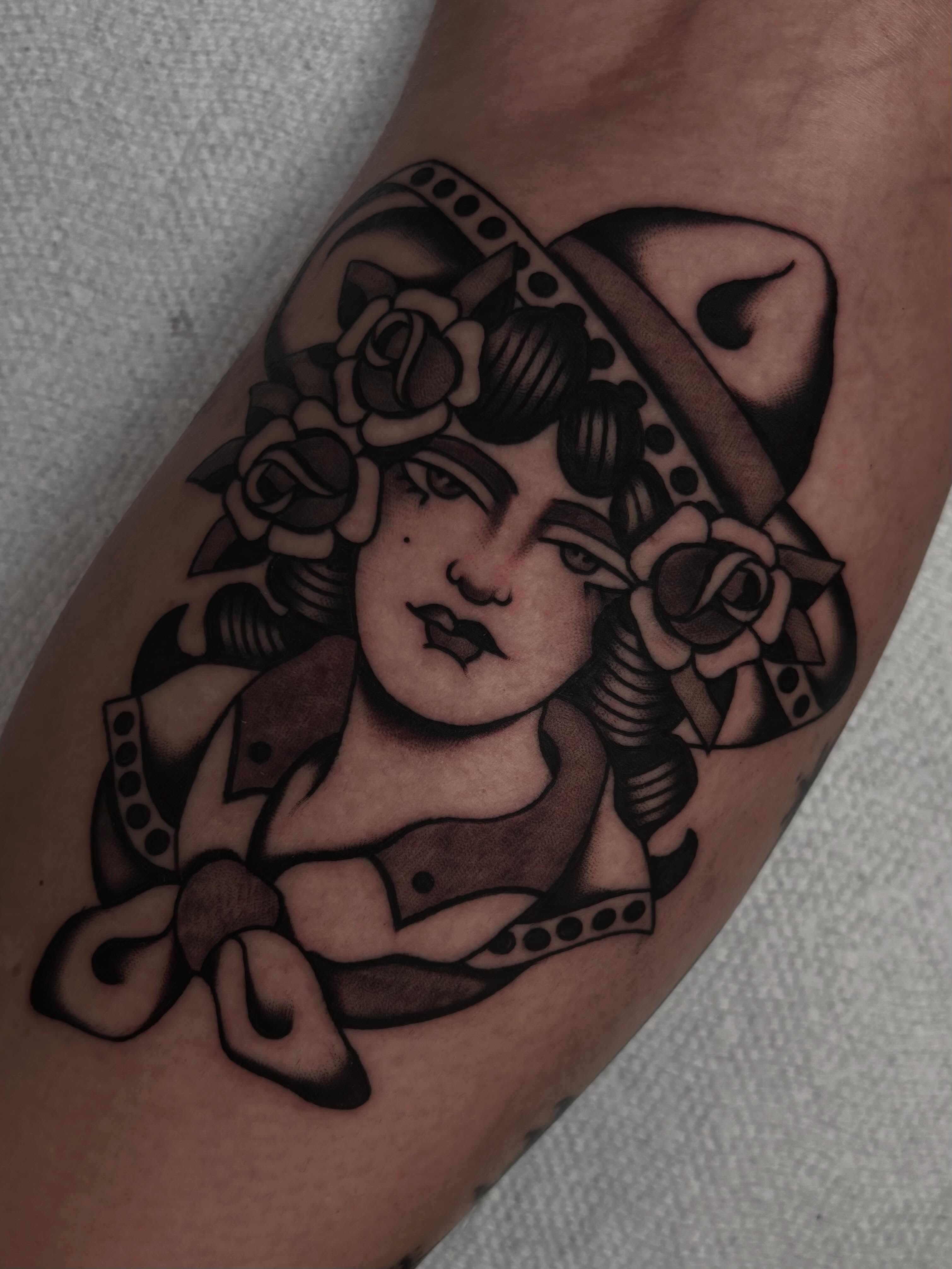 Woman with roses American traditional tattoo on the forearm by Claire Anderson