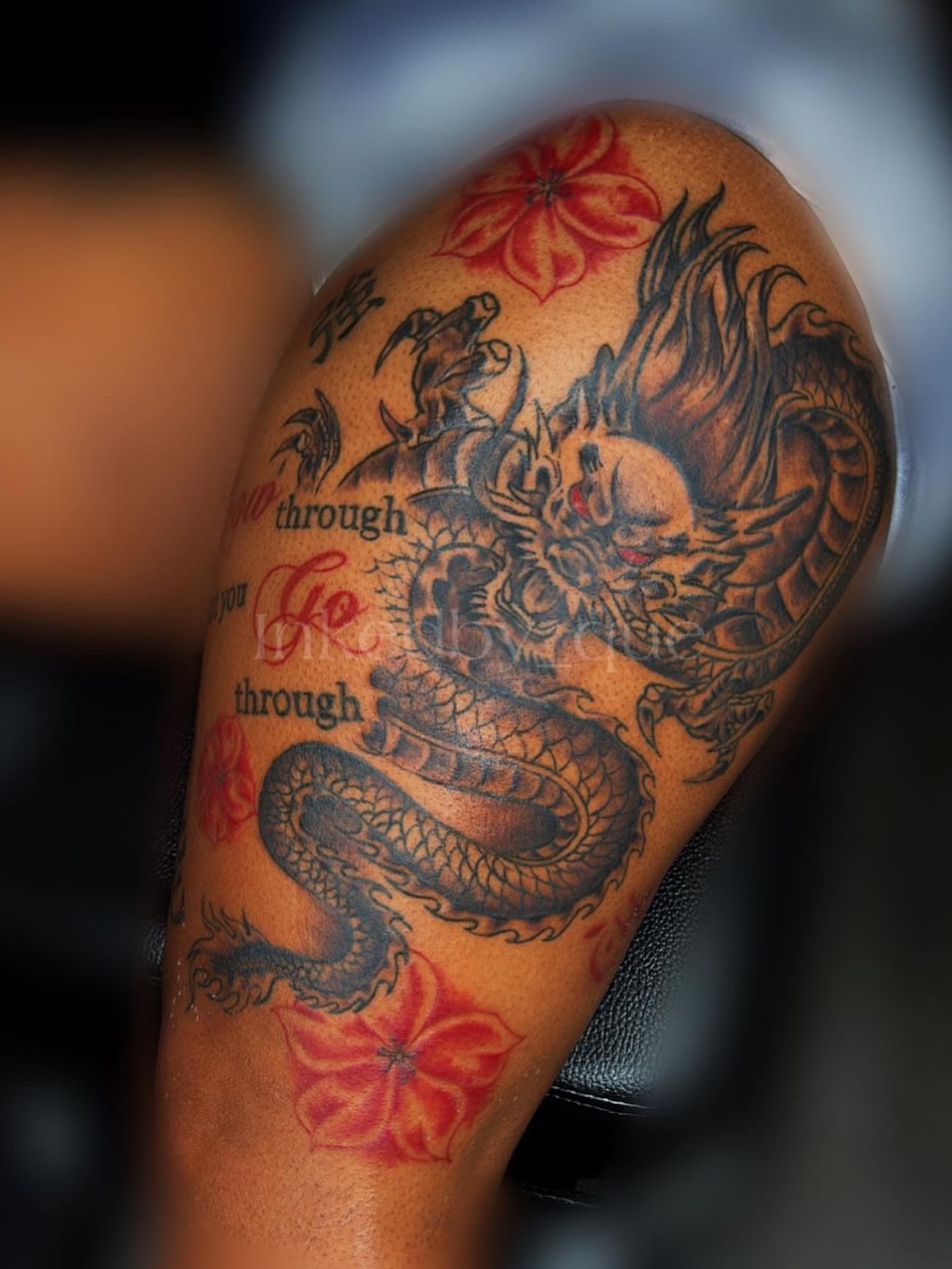 Dragon and flowers black and grey tattoo on the upper arm by Q⚜️