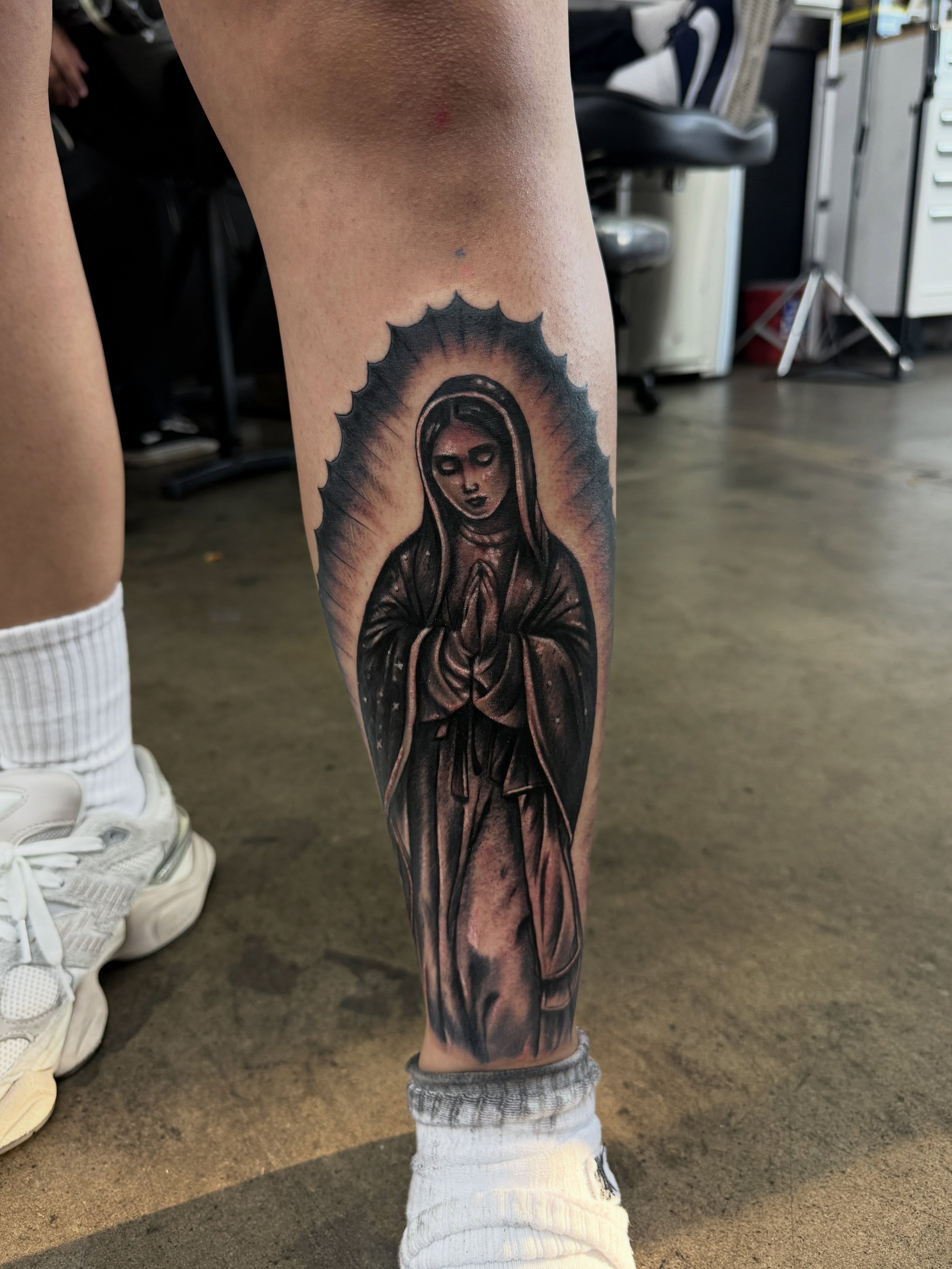 Religious figure black and grey tattoo on the calf by @samg_tat2s, San Diego, California