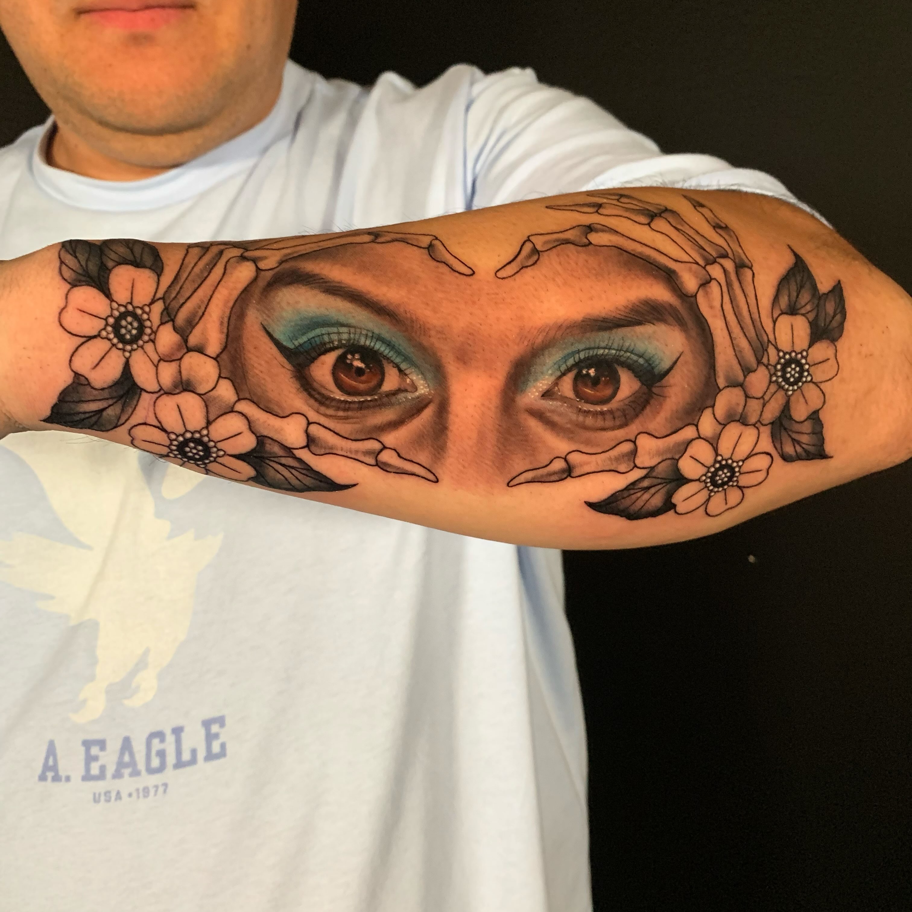Eyes and flowers realism tattoo on the forearm by HAiZiE