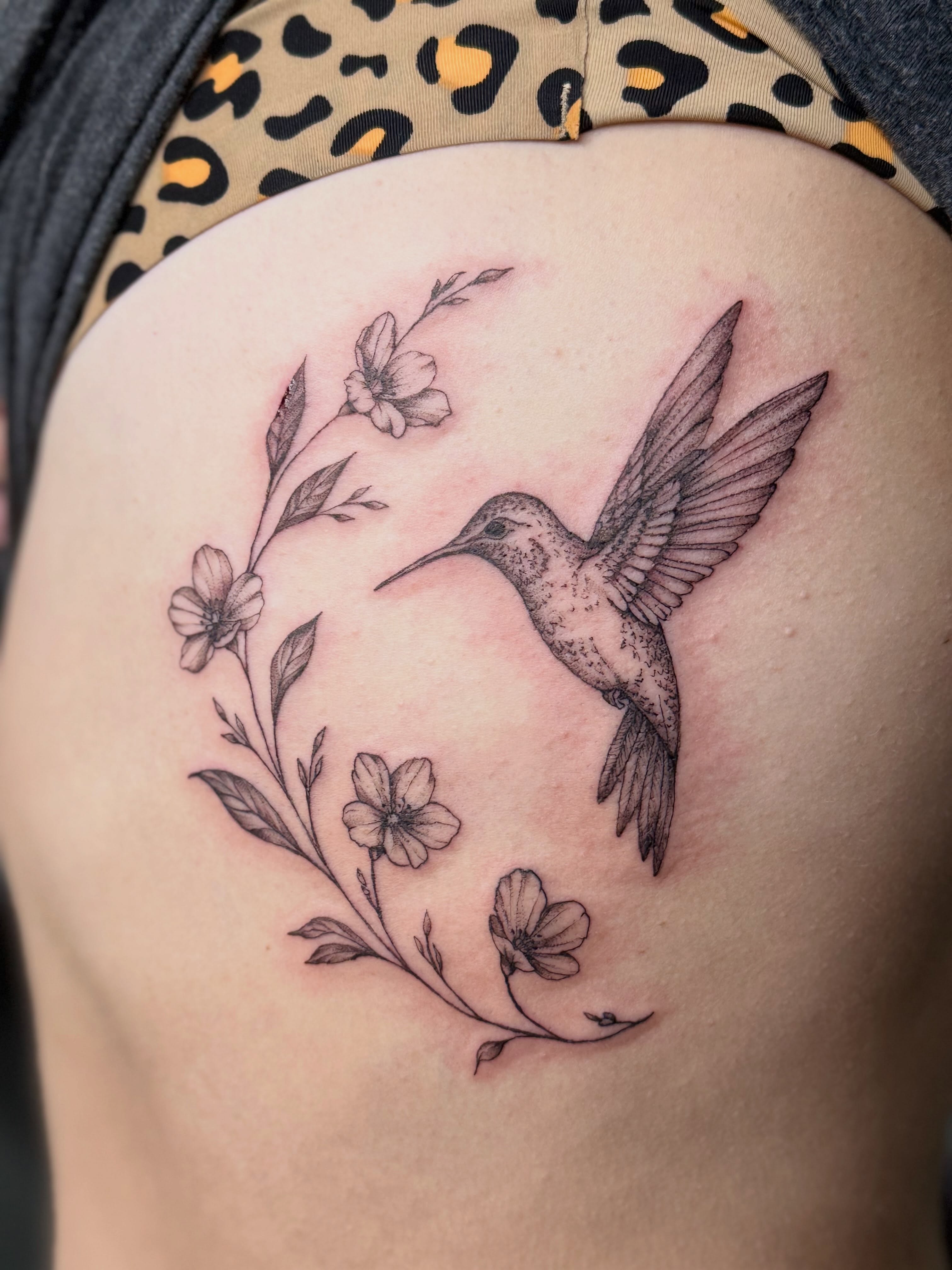 Hummingbird and flowers black and grey tattoo on the shoulder by Tetiana
