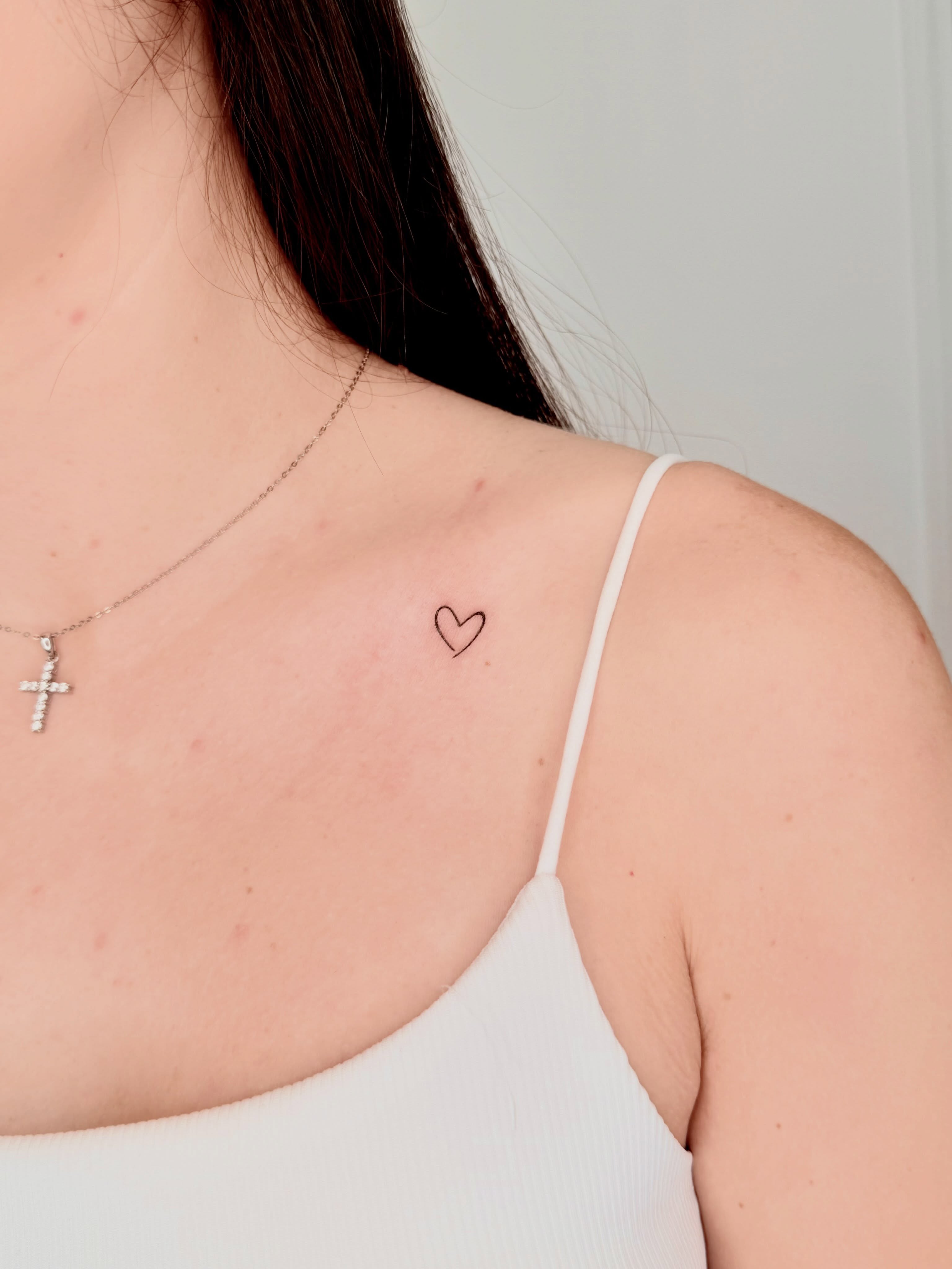Heart fine line tattoo on the chest by Fine Line Tattoo Artist