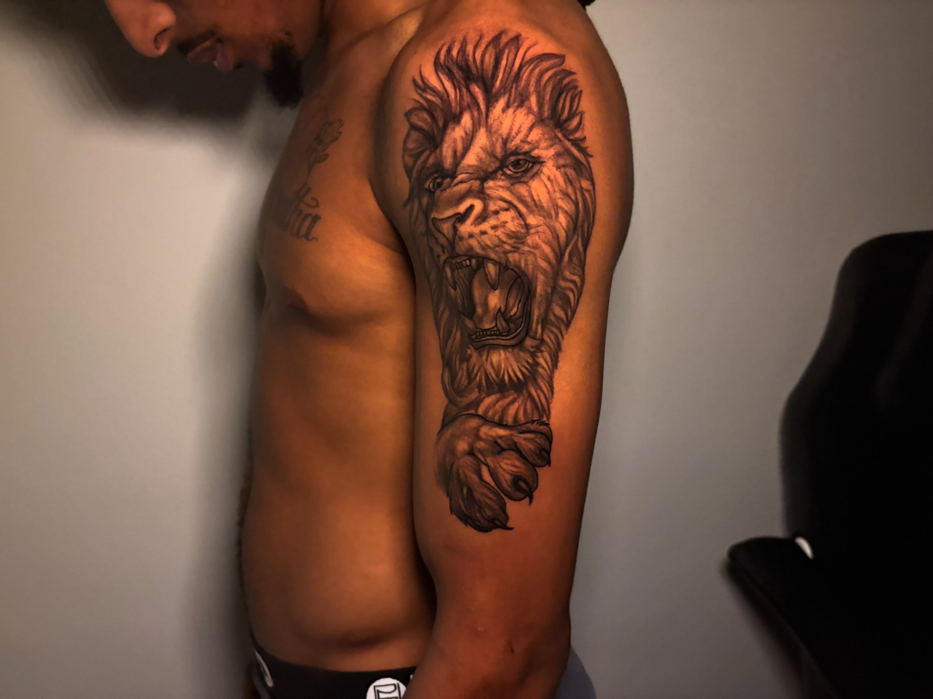 Lion realism tattoo on the upper arm by Inkys Tatts