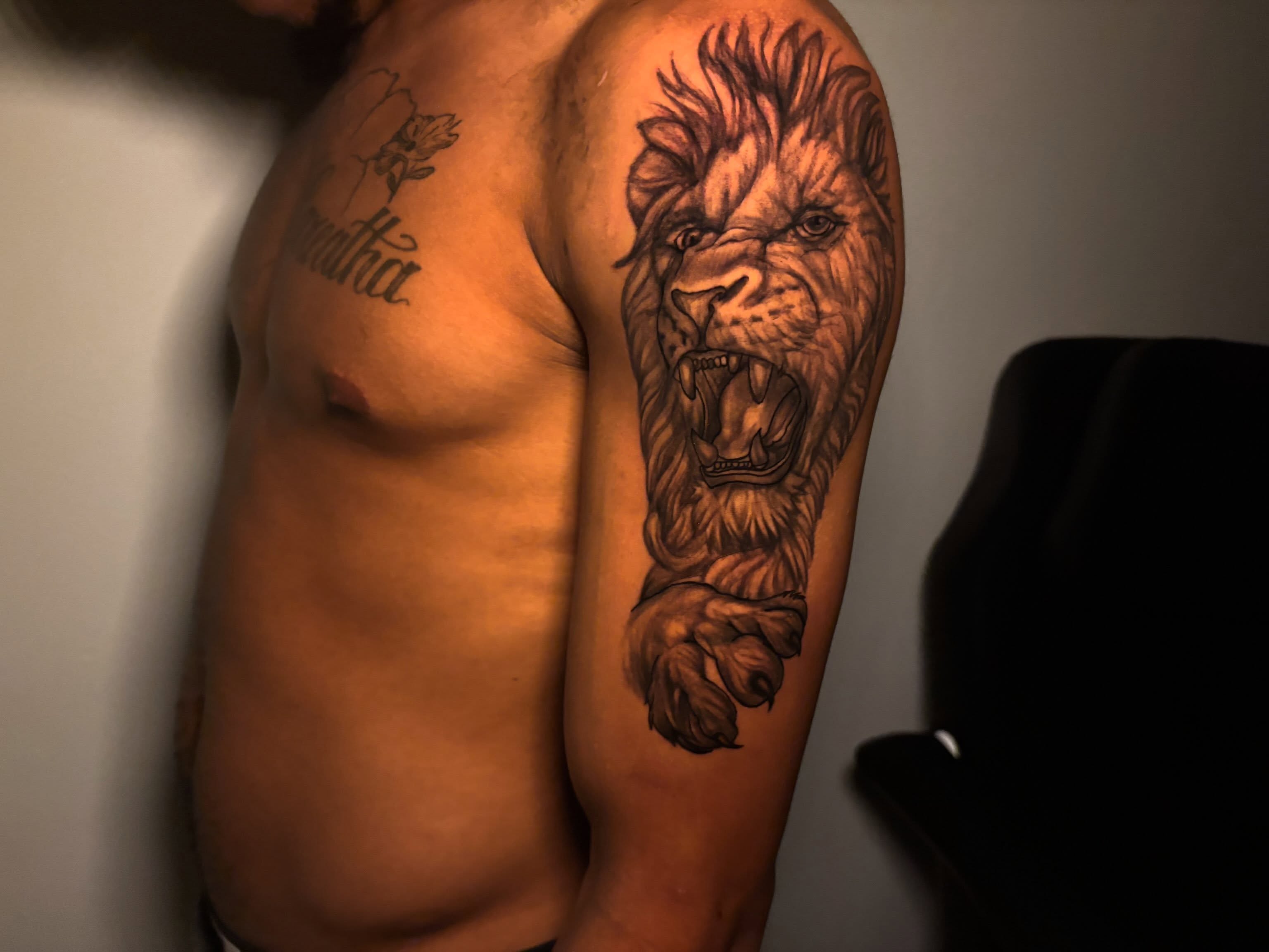 Lion black and grey tattoo on the upper arm by Inkys Tatts