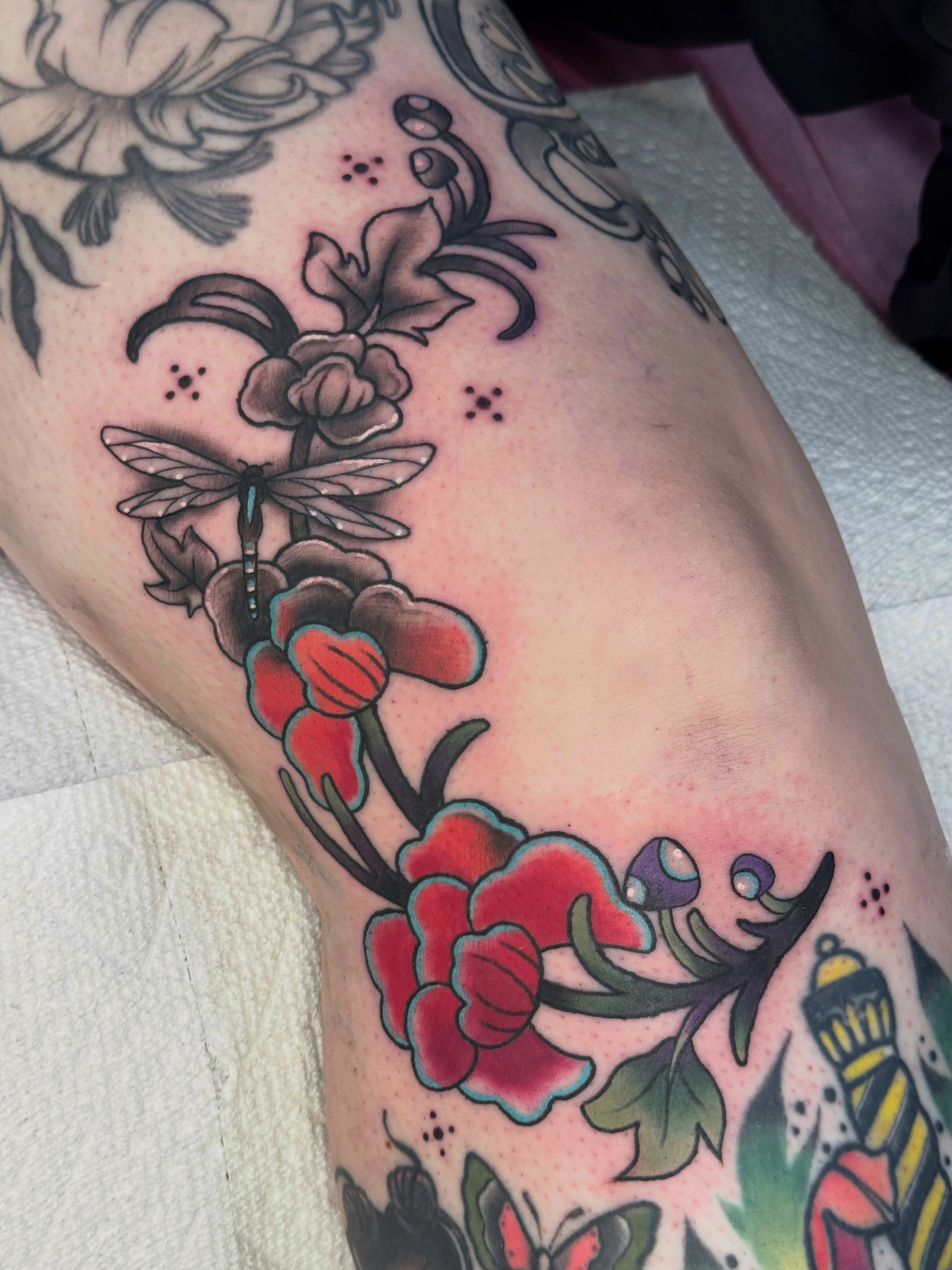 Floral arrangement with dragonfly American traditional tattoo on the thigh by Tattoos by Angel Lee