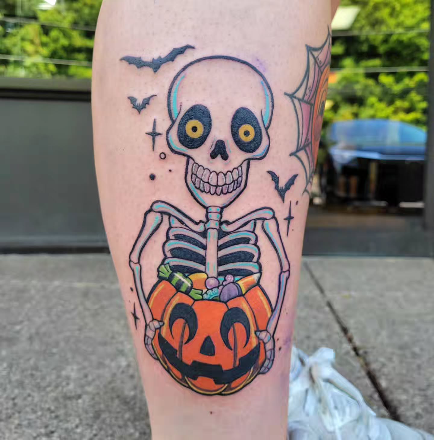 Skeleton holding jack-o'-lantern American traditional tattoo on the forearm by Jessica Czernics, Pittsburgh, Pennsylvania