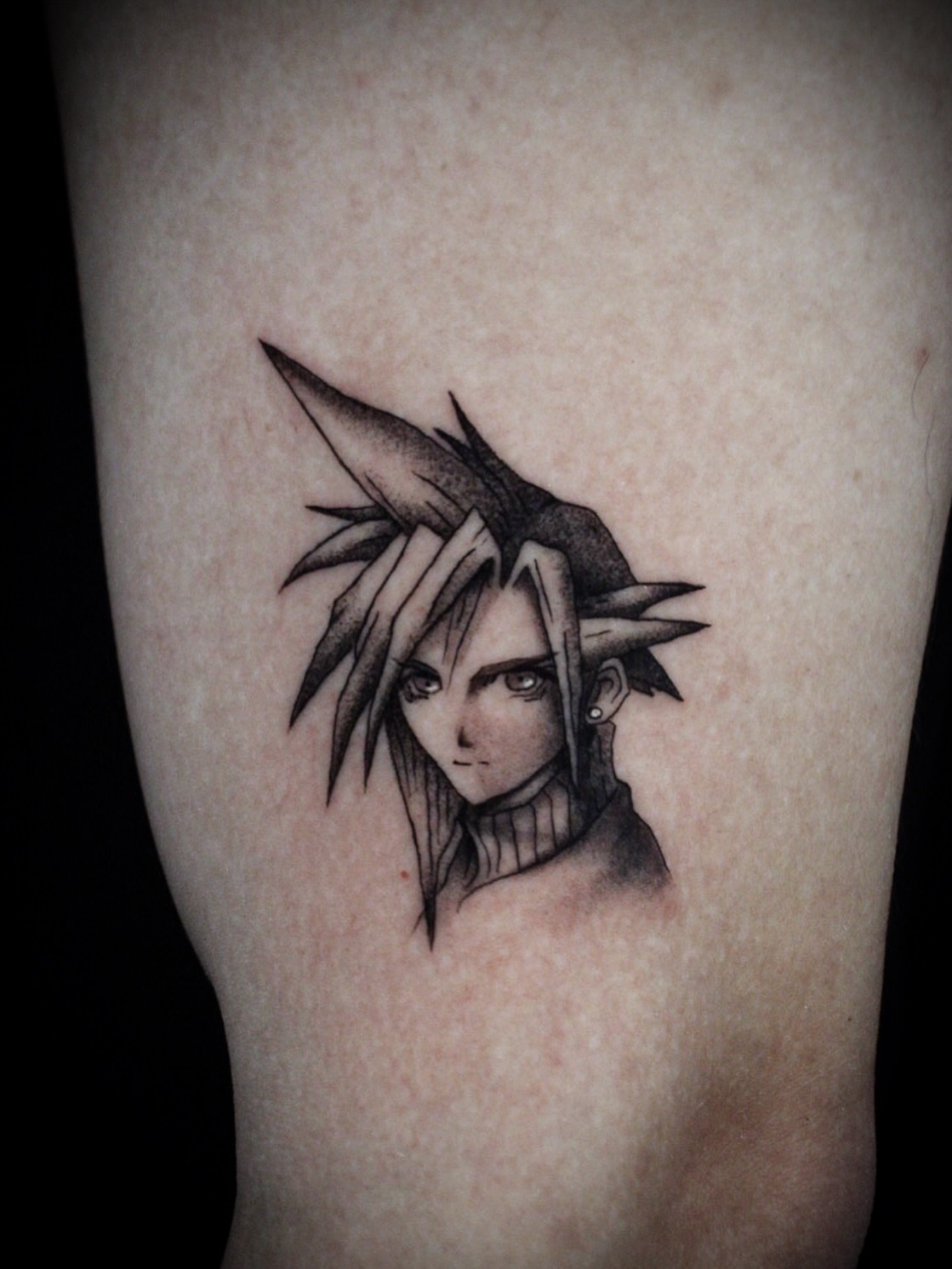 Spiky-haired character black and grey tattoo on the forearm by Kanya, Alhambra, California