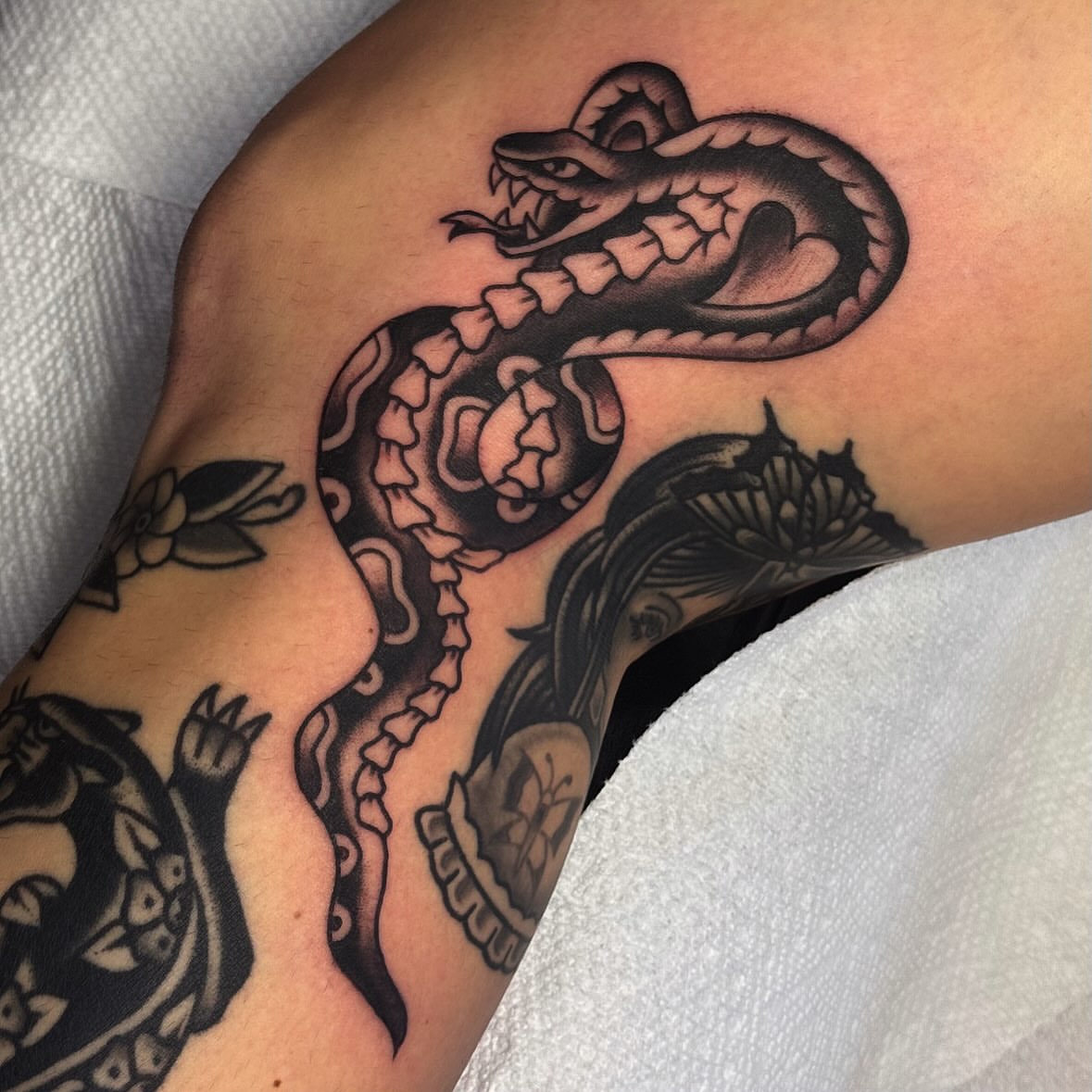 Snake American traditional tattoo on the forearm by Larry Love