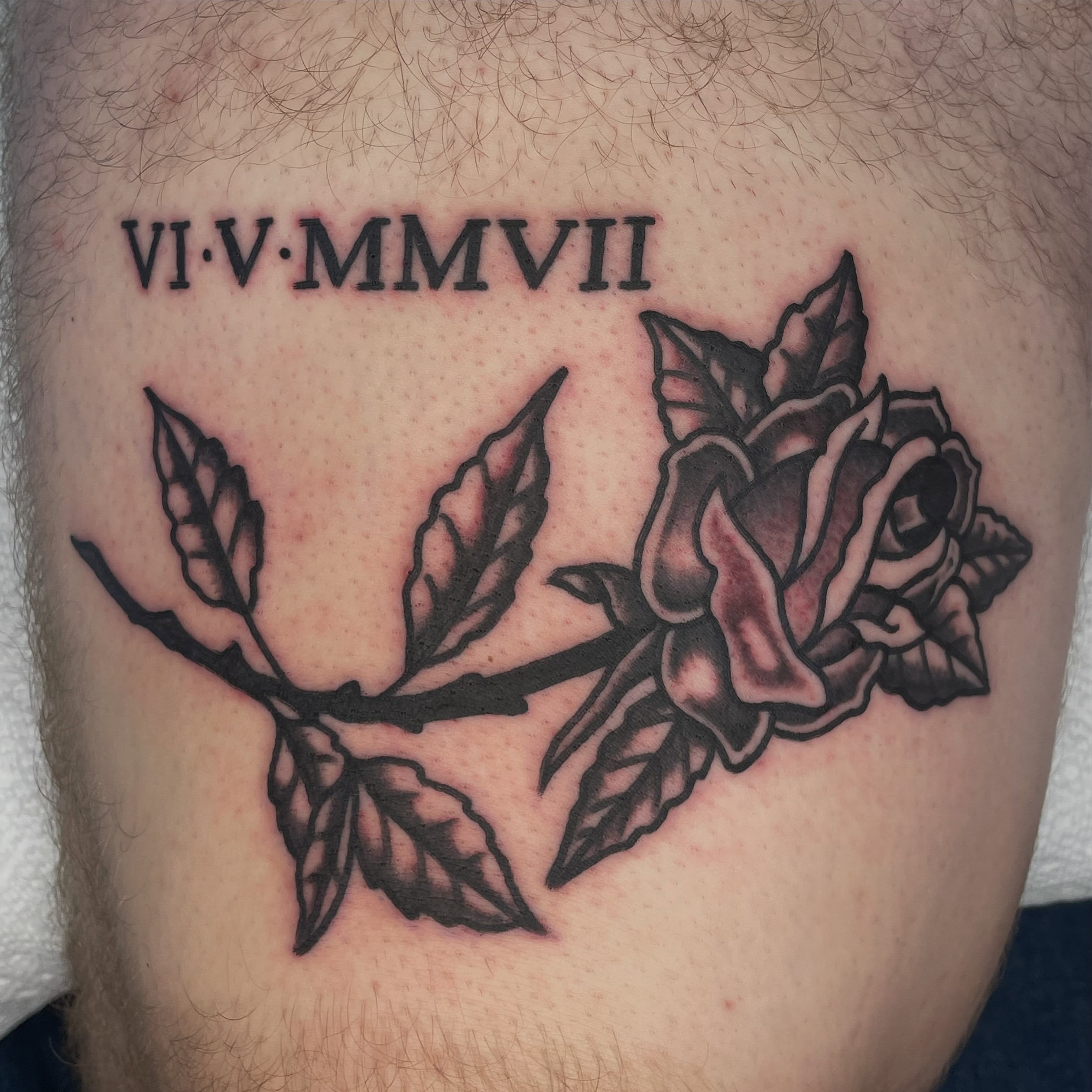Rose branch black and grey tattoo on the thigh by Nicholas M. Passeri