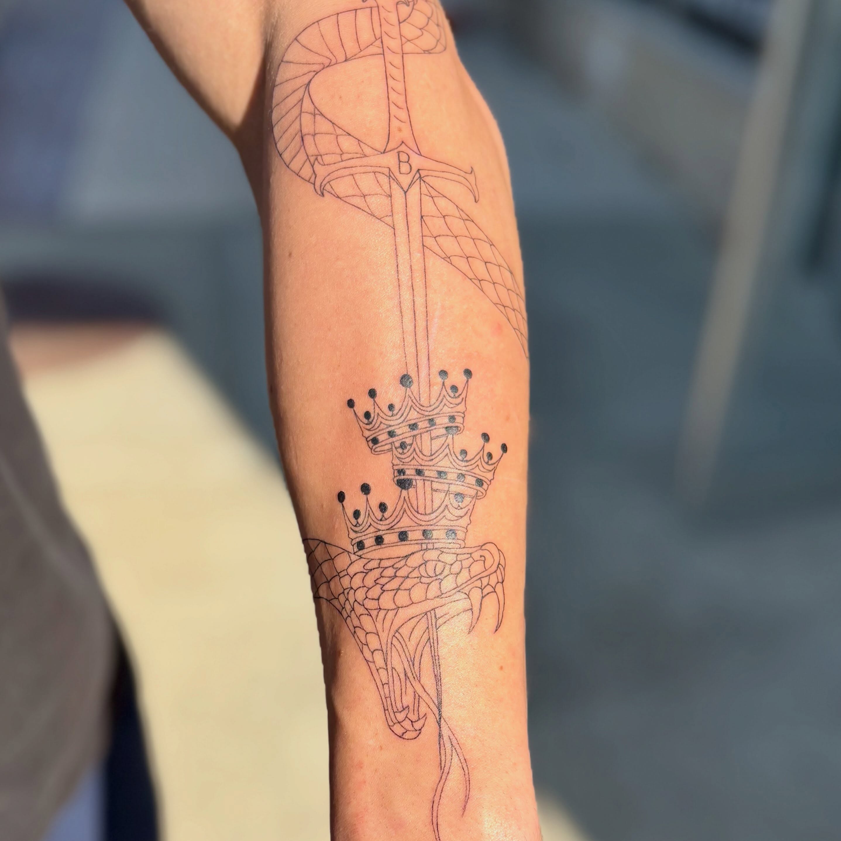 Sword and crown black and grey tattoo on the forearm by bradyn thornton: eco-tattoo artist