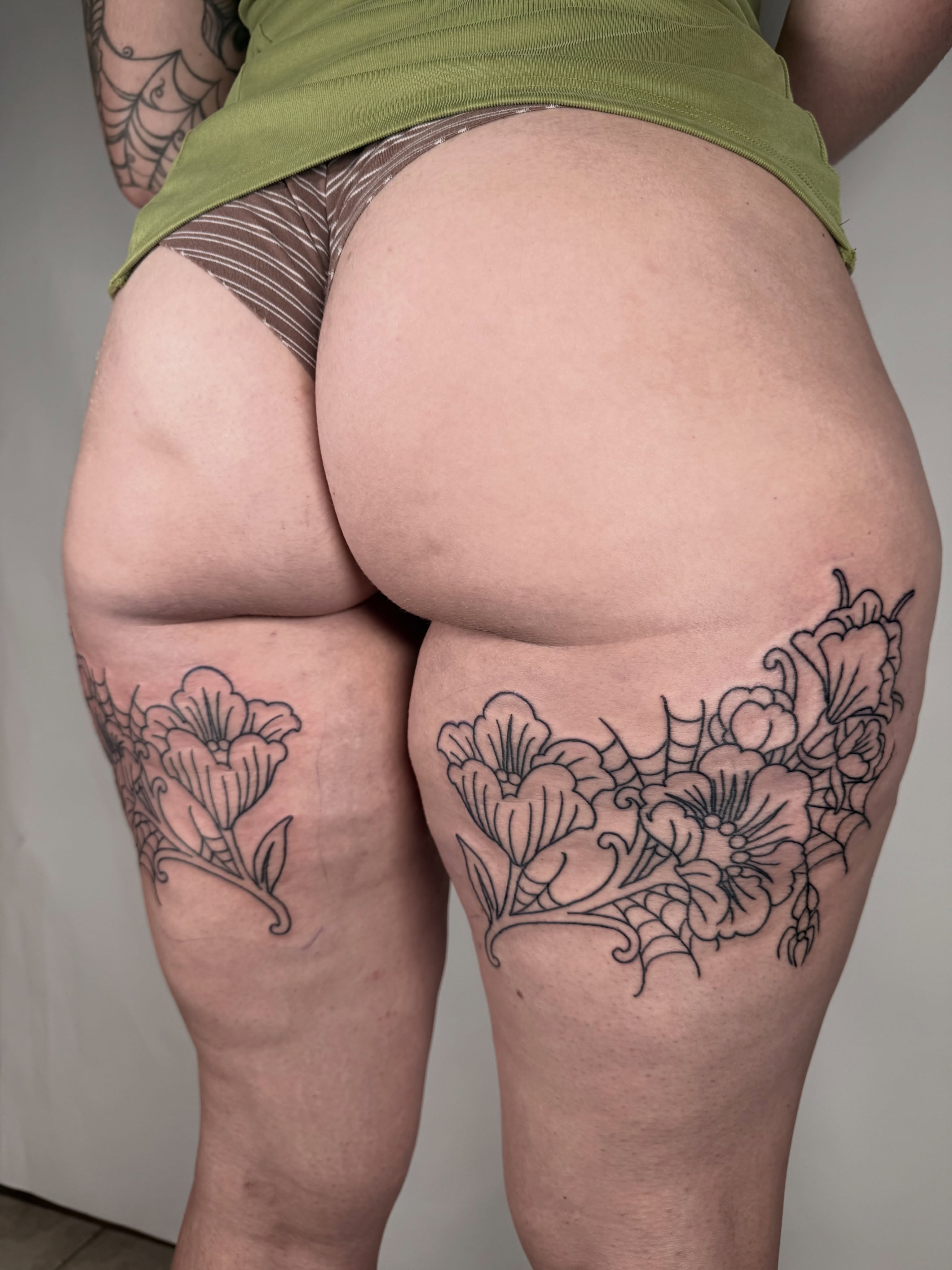 Floral black and grey tattoo on the thigh by autumn sky